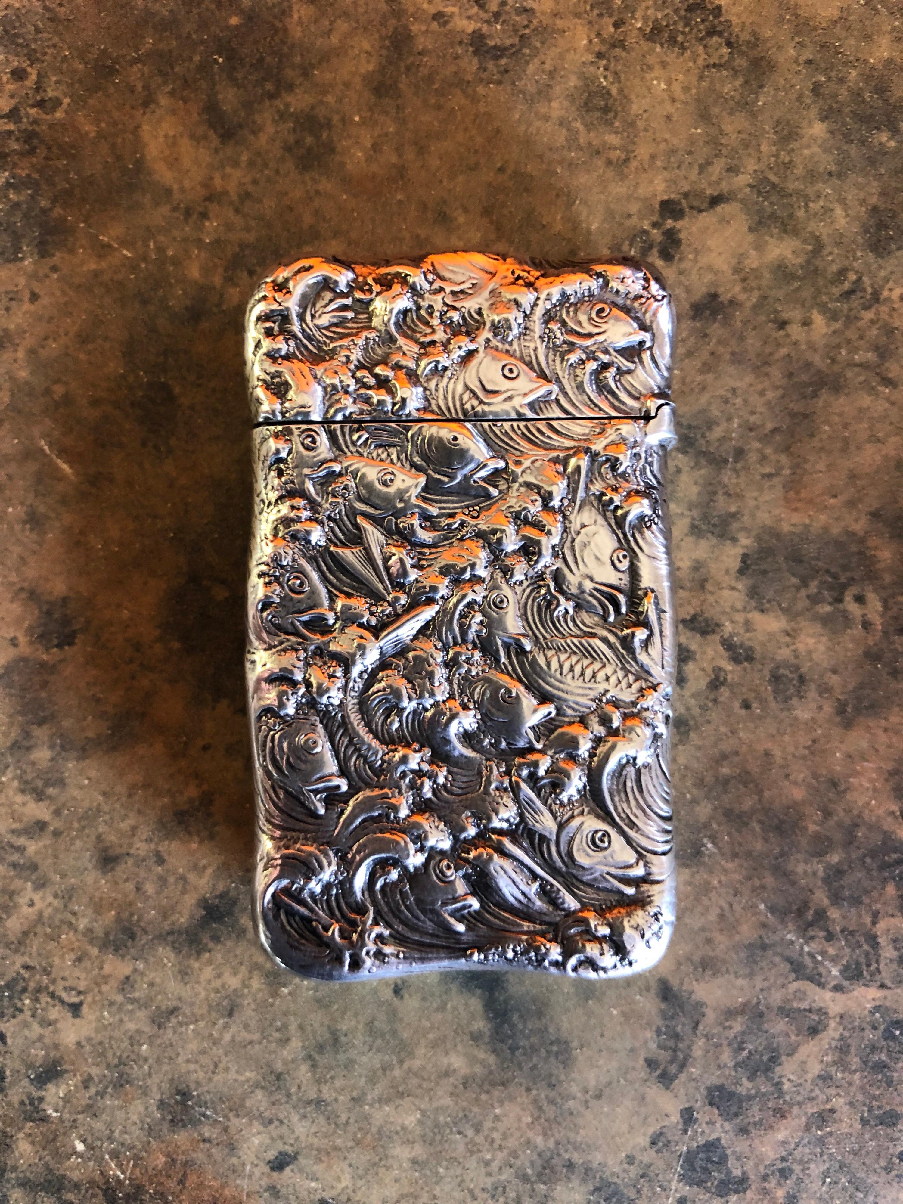 American sterling silver repousse match safe / vesta with an ornate all-over fish design on both sides, circa 1900s. The match holder measures 2.5