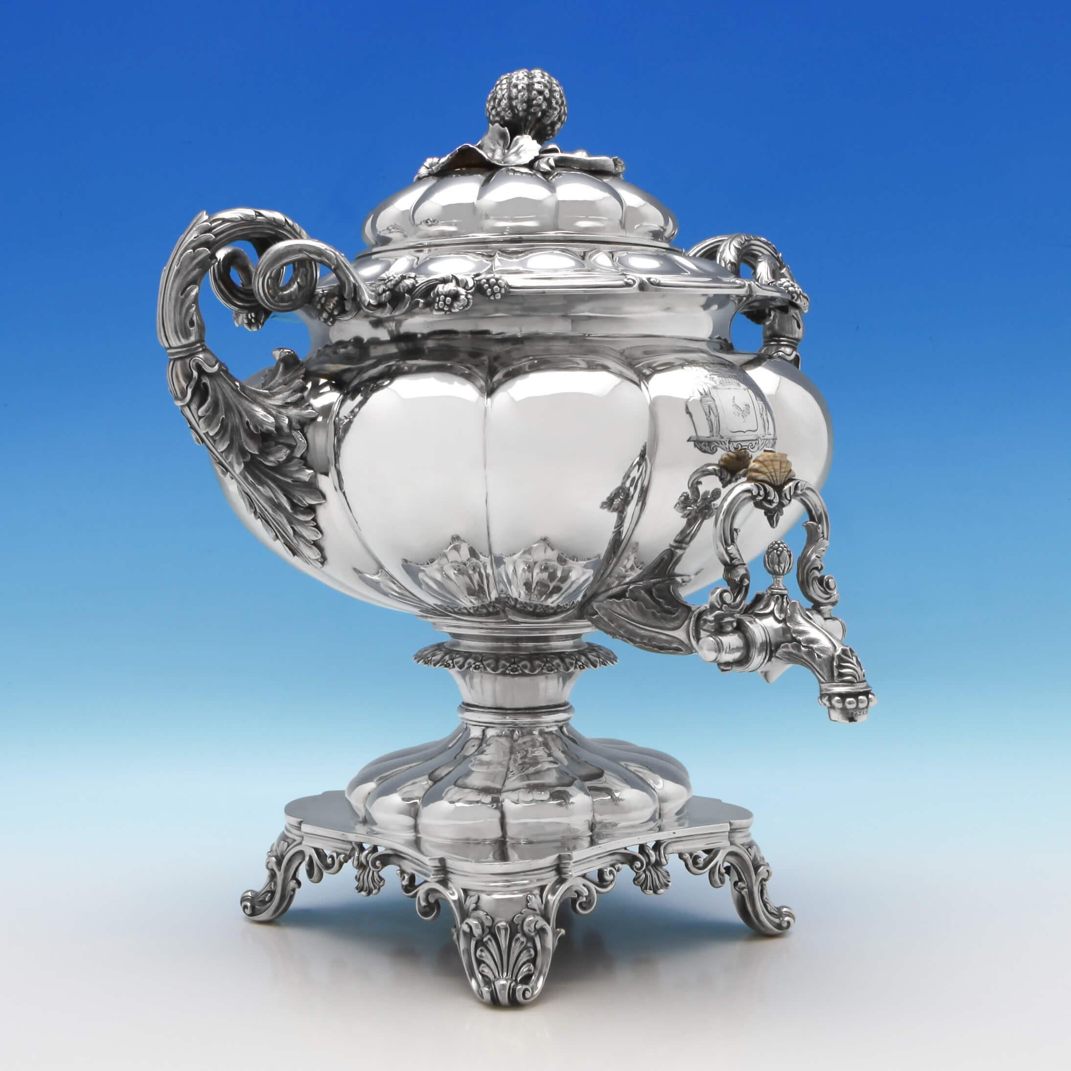 Hallmarked in London in 1828 by Barnards, this impressive antique, George IV, sterling silver five-piece tea and coffee service is in the famous Barnard's Melon design and features shell feet, pumpkin finials, and an engraved coat of arms to the