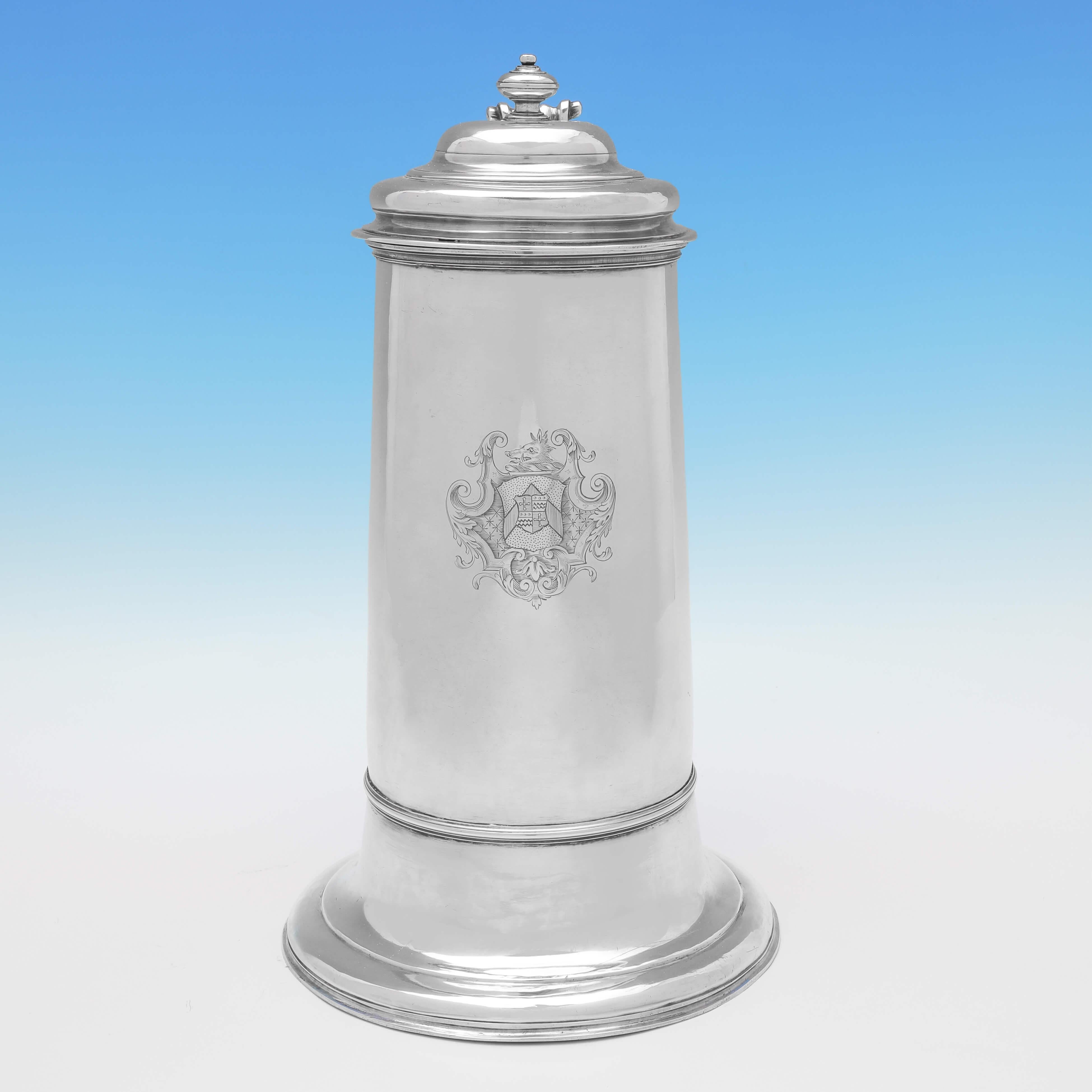 Hallmarked in London in 1730 by Thomas Tearle, this handsome, George II, antique silver flagon, stands on a flared base, and features a wonderfully engraved coat of arms. The flagon measures 13.75