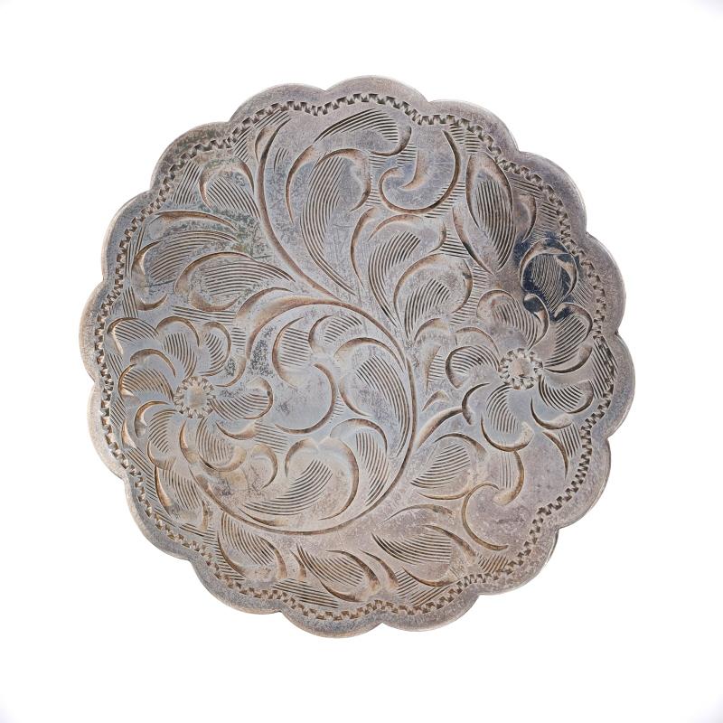 Metal Content: Sterling Silver

Style: Brooch
Fastening Type: Hinged Pin and Whale Tail Bullet Clasp
Theme: Floral Scallop Circle, Medallion
Features: Etched Detailing

Measurements
Tall: 2