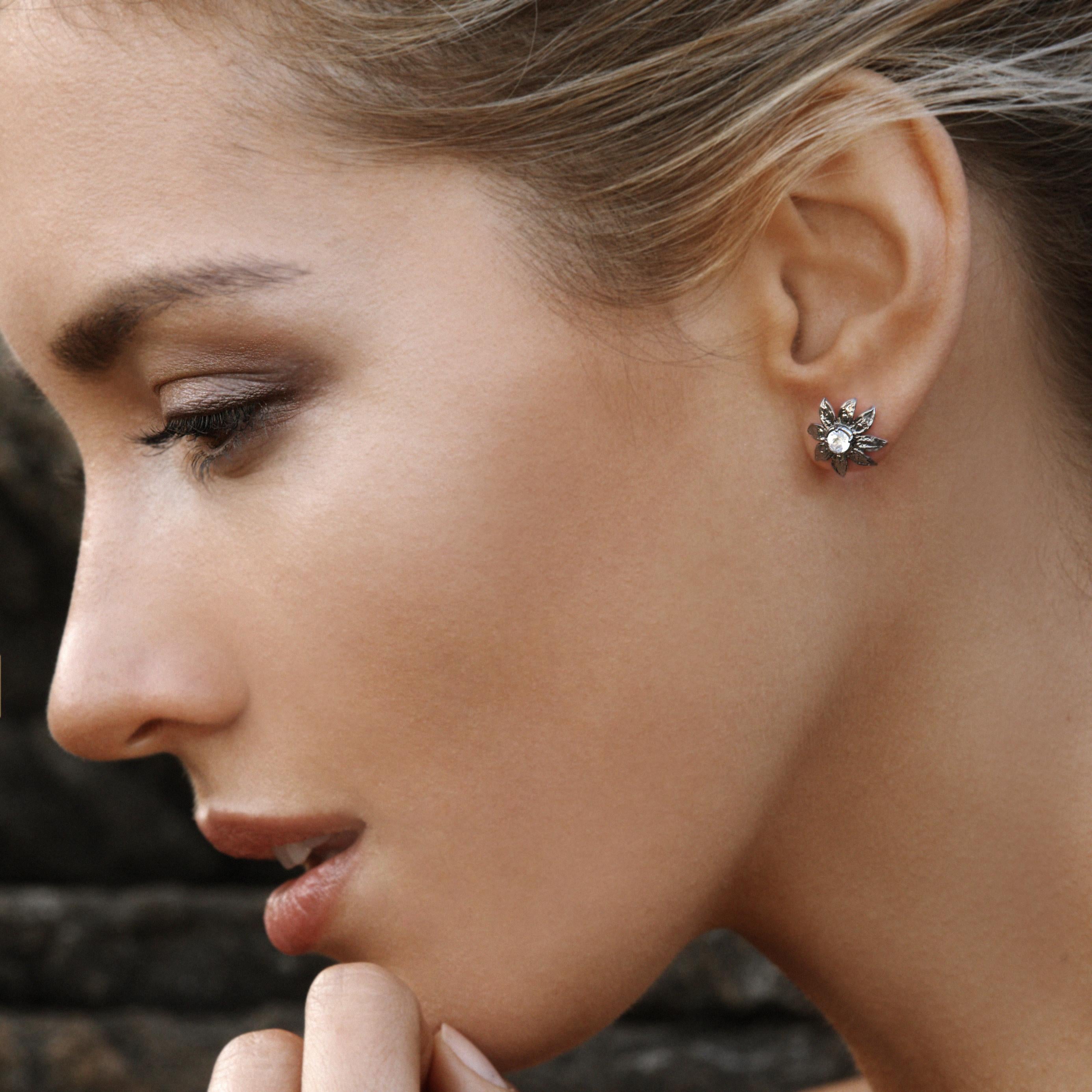 The Clematis stud earring is a natural fashion silhouette of relaxed petals emanating from a sparkly cut blue moonstone center. The sterling silver earring with 14kt gold posts hugs the earlobe perfectly.

Sterling silver w/ 14kt post
Moonstone