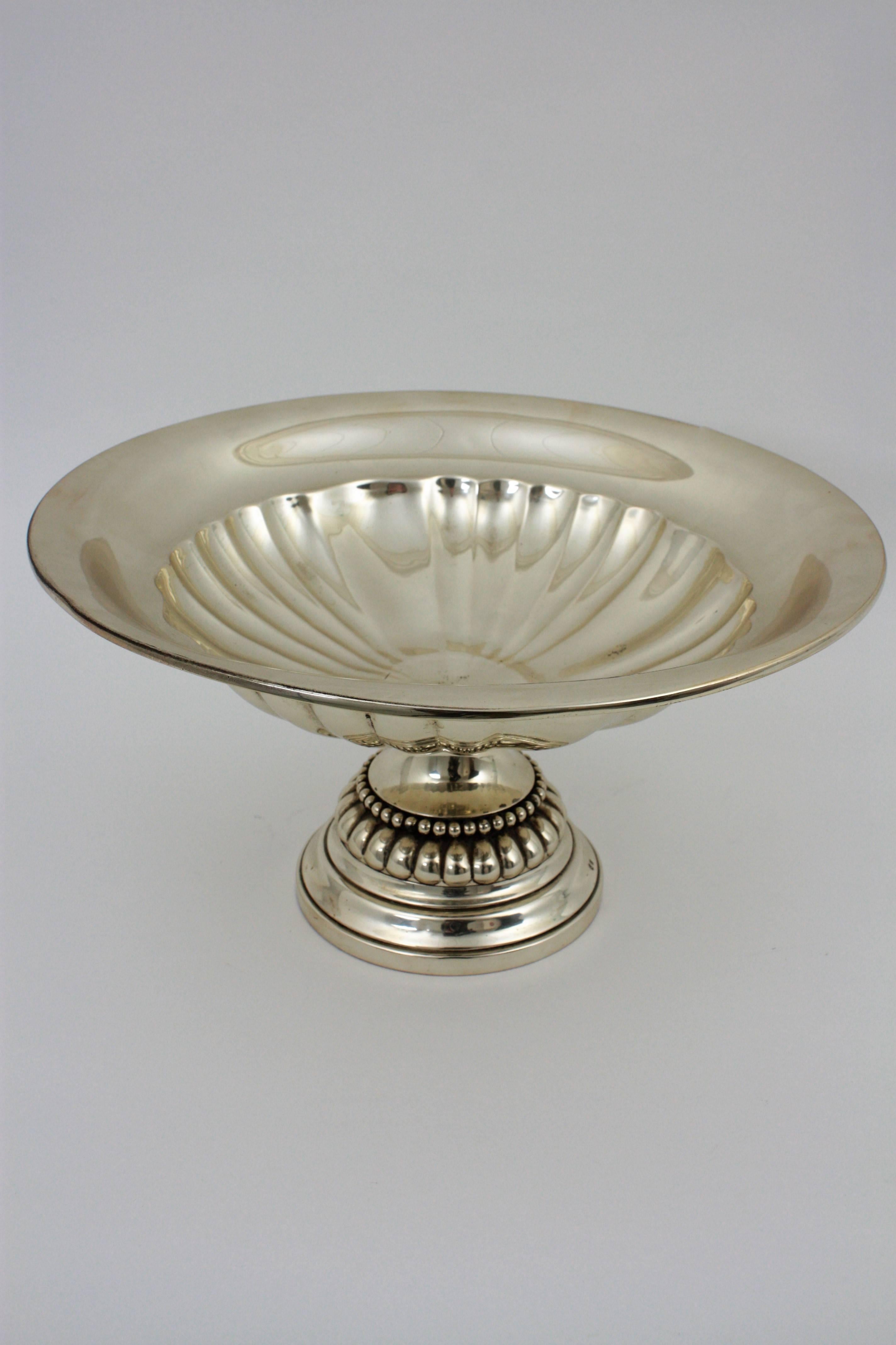 Elegant neoclassical style Tazza centerpiece, sterling silver. Spain, 1950s.
This exceptional spanish sterling silver bowl has a circular shaped form onto a spreading foot.
Measures: Height: 19 cm
Diameter: 36 cm
Stamps: Star - 925 
Weight: