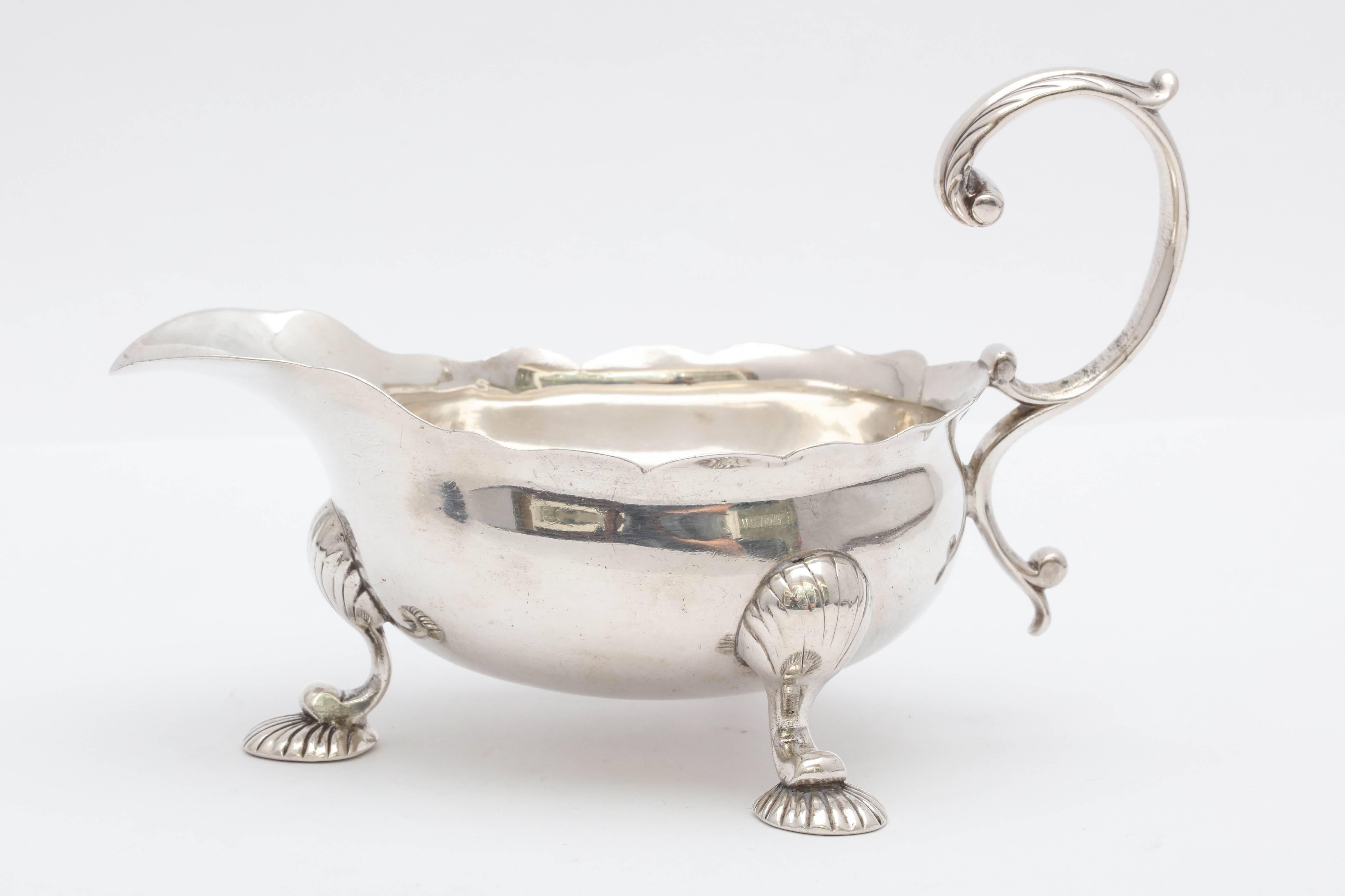 Sterling silver, shell-footed, George II sauce/gravy boat, London, 1753, Samuel Herbert and Co. - makers. Measures 6 inches from edge of handle to edge of spout x 3 1/2 inches deep (edge of foot to edge of foot) at deepest point x 3 1/2 inches high