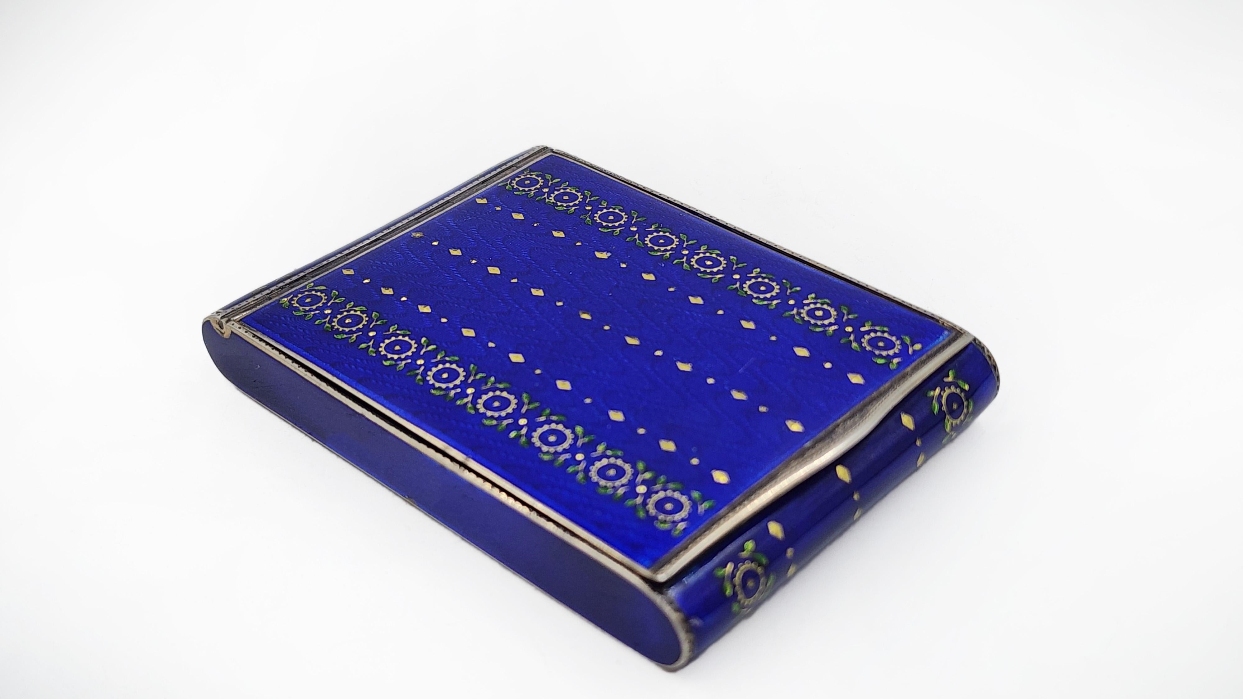 Frances Sterling Silver Box with Enamel Design
This rectangular sterling silver box with rounded corners features vibrant cobalt blue enamel. The lid is decorated with a central design of gold dots forming a diamond shape, flanked by two vertical