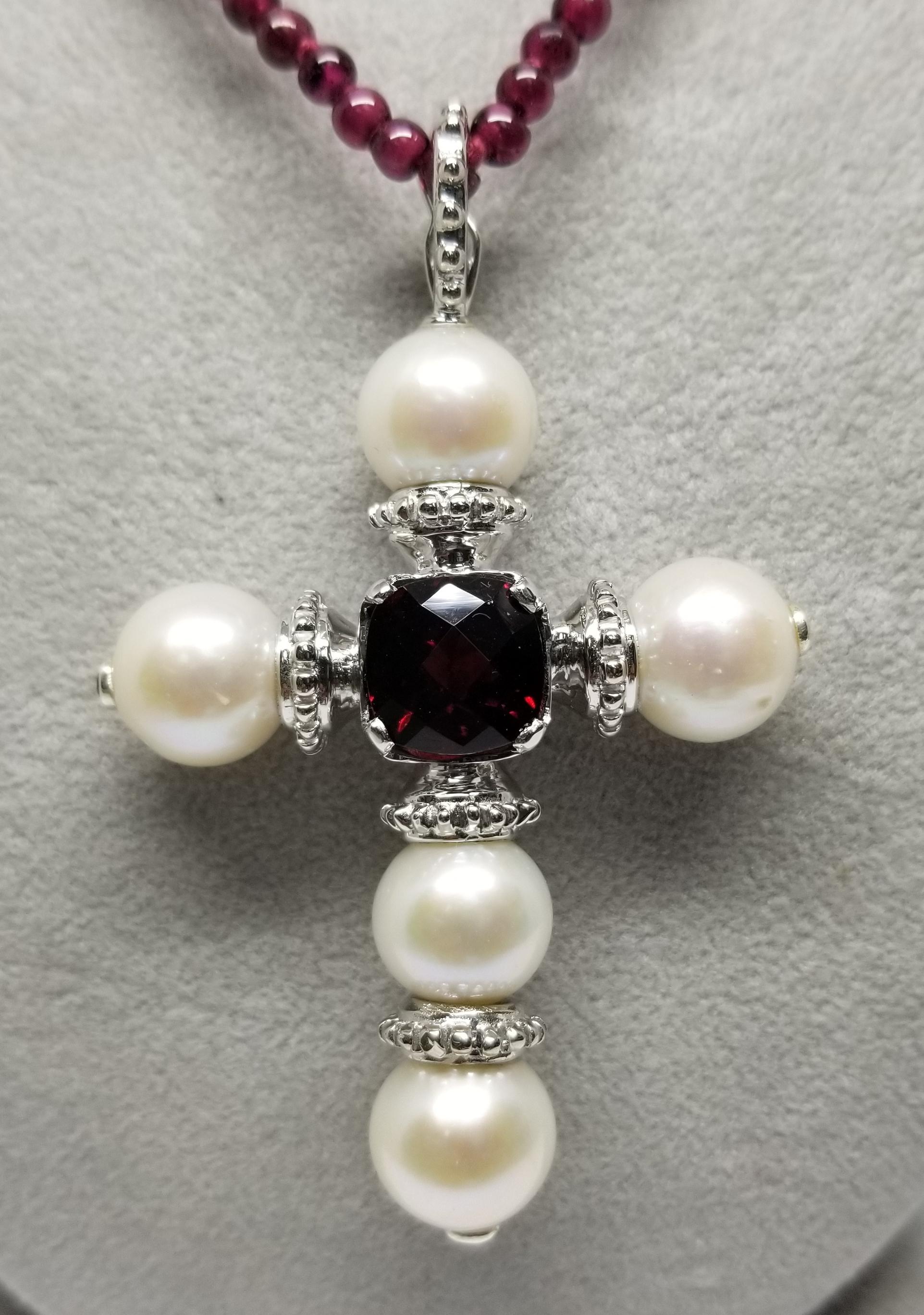 Sterling Silver Fresh Water Pearl cross with 5 pearls measuring 10.5mm, with a cushion cut garnet weighing 5.48cts.,  3 round garnets as accents on the ends of the pearls set in a bezel.  The clasp can open and be put on pearls or as a bail on a