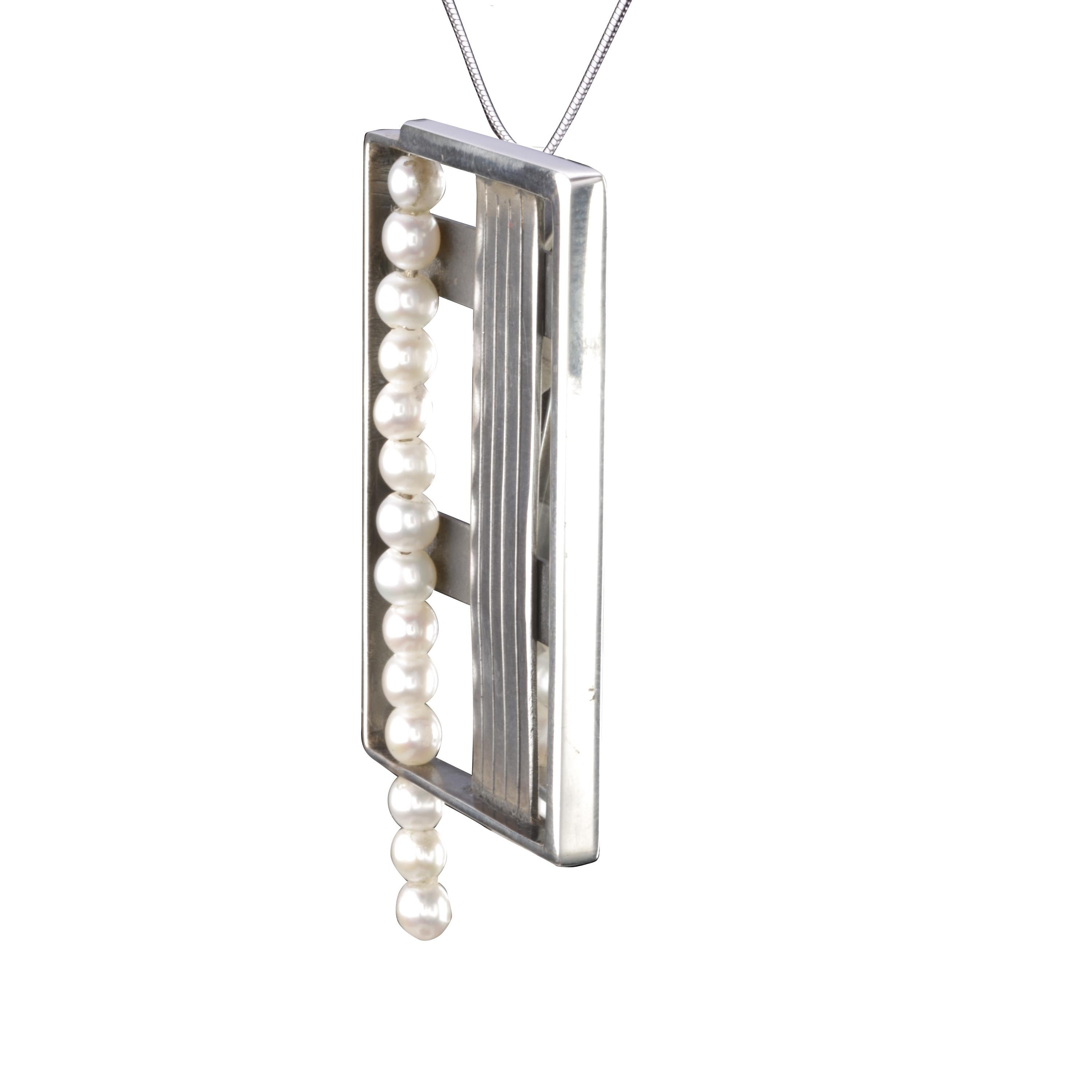 This sculptural-style pendant is handmade in Sterling Silver with freshwater pearls.
The lines on the vertical silver part are hand-engraved.
The remoivable, super-plane, minimalist long silver chain is included in the price. 
Designed and handmade