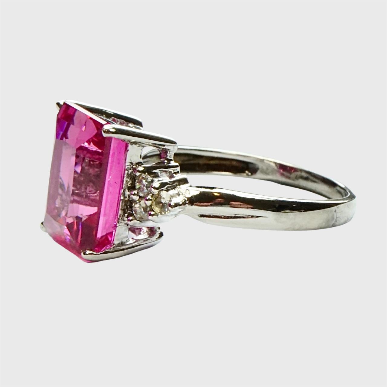 Beautiful sterling silver dress ring, set with a lovely fuschia pink topaz and cubic zirconia shoulders. The topaz has been heat treated.

Ring size UK K 1/2,  US 5 3/8, inside diameter 1.7 cm / .67 inch. The topaz measures 1.1 cm / .43 inch by 85