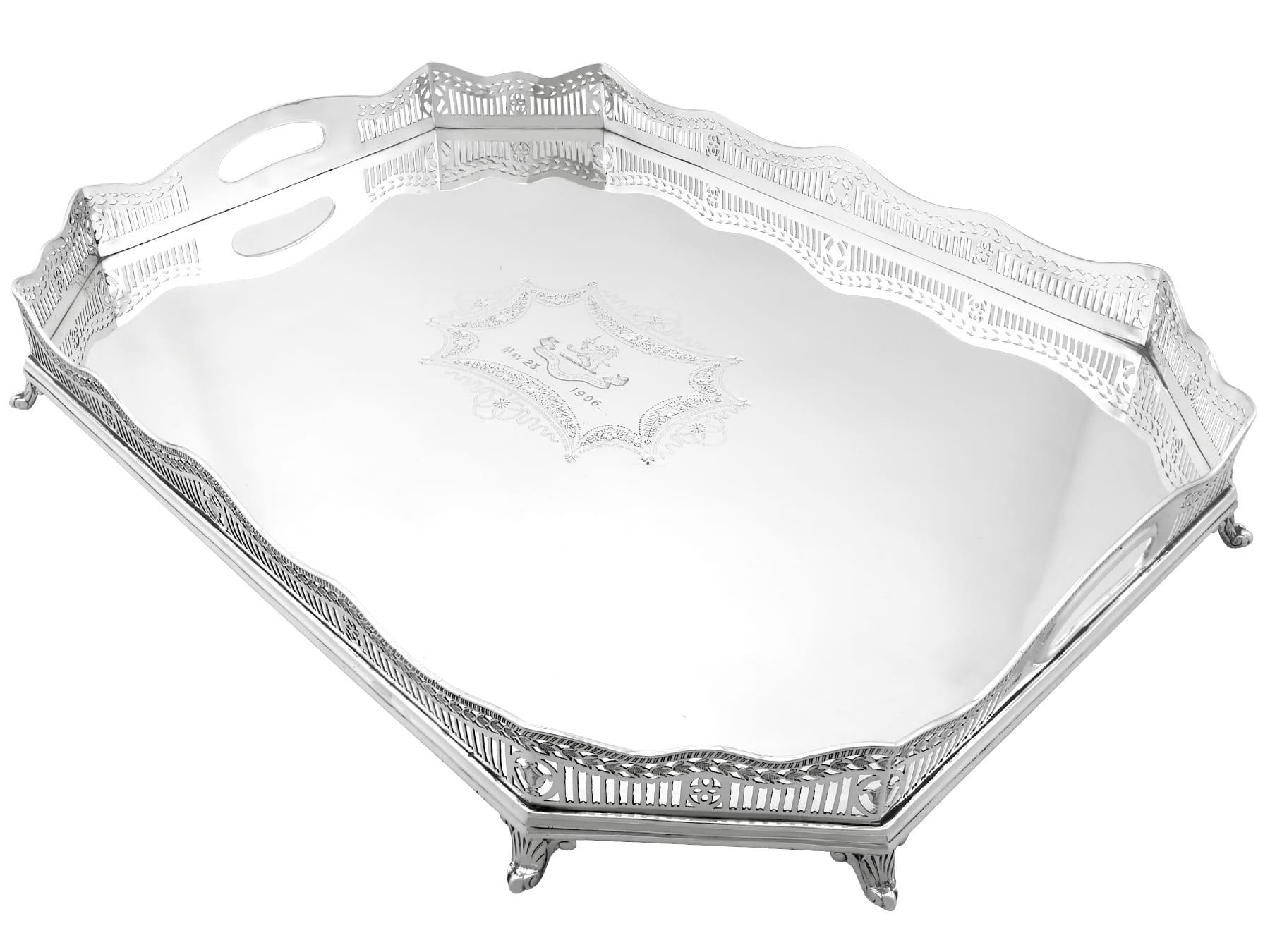 This magnificent antique Edwardian sterling silver tray has a rectangular cut-cornered shaped form.
The surface of this sterling silver serving tray is embellished with an impressive contemporary bright cut engraved cartouche, reflecting the shape