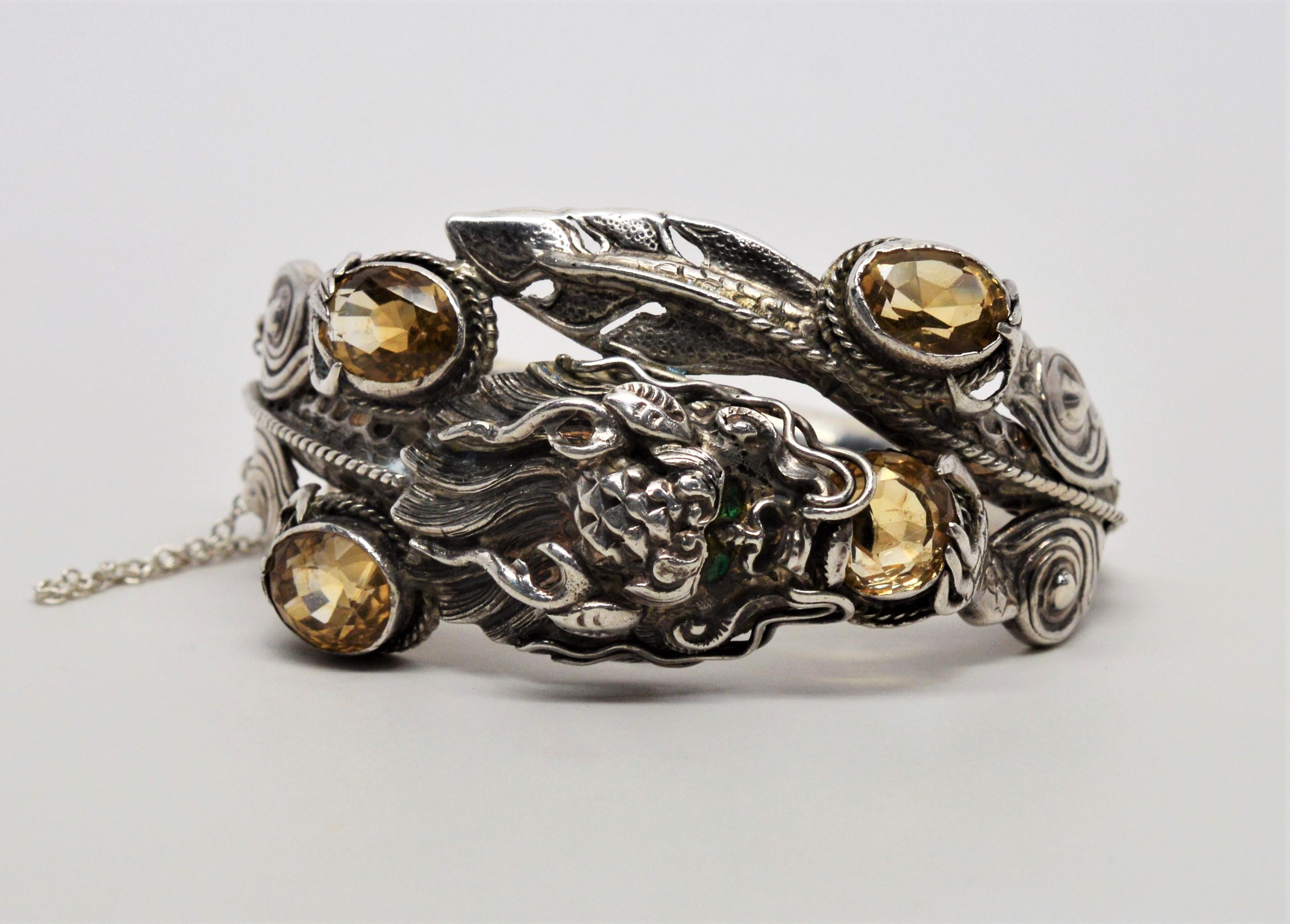 Intense green eyes of emerald peer from the Gargoyle's uniquely curious image handmade in sterling silver on this cuff bracelet.
Surrounded by four 8 -10 mm oval citrine gemstones, this craftsman's piece is assembled from at least sixteen separate