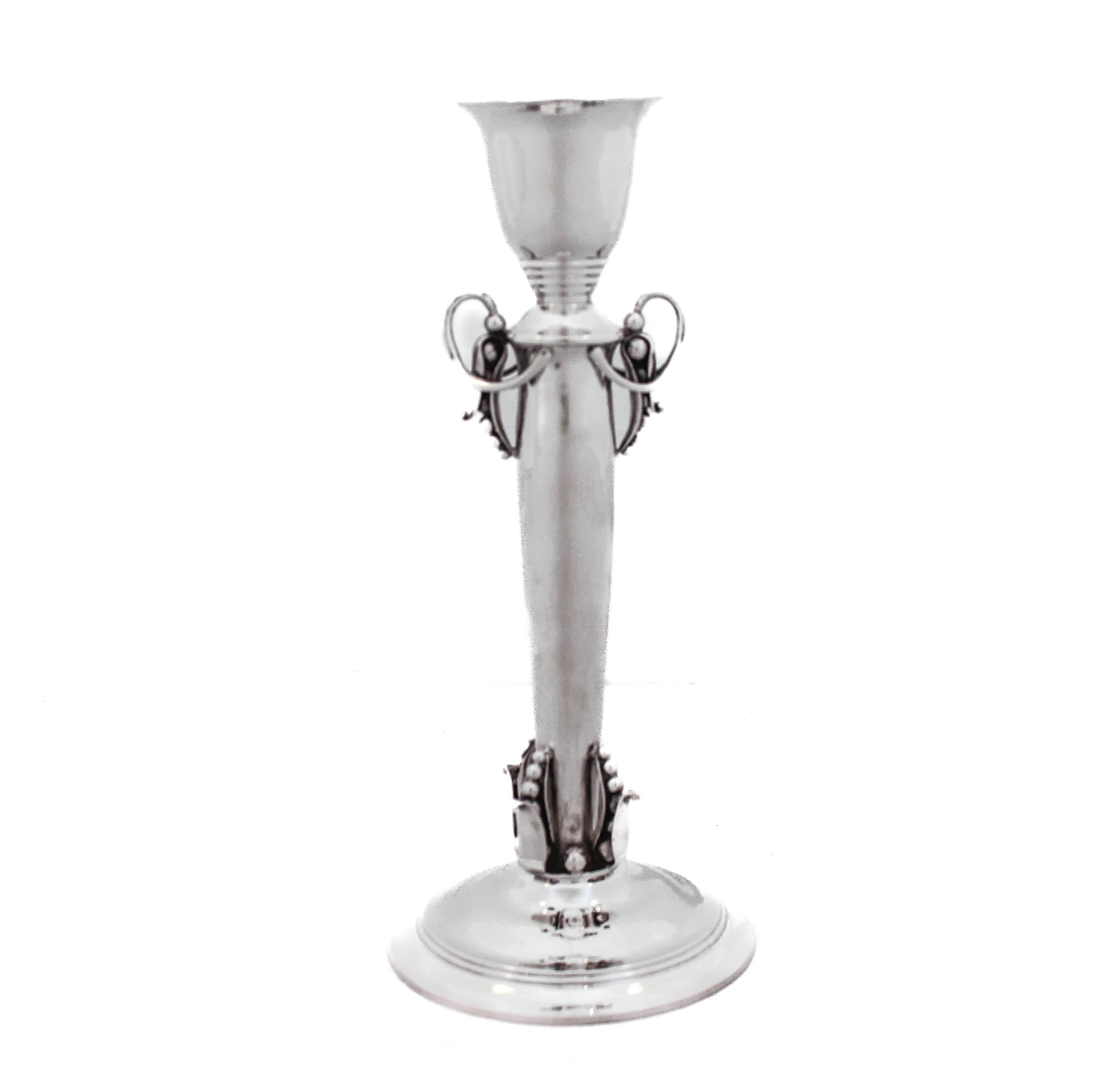 Estamos encantados de ofrecerte este par de candelabros de plata de ley de Georg Jensen.  La plata de Jensen está en lo más alto en cuanto a calidad, artesanía y diseño.  Estos candeleros tienen los tres elementos característicos.  Están ligeramente