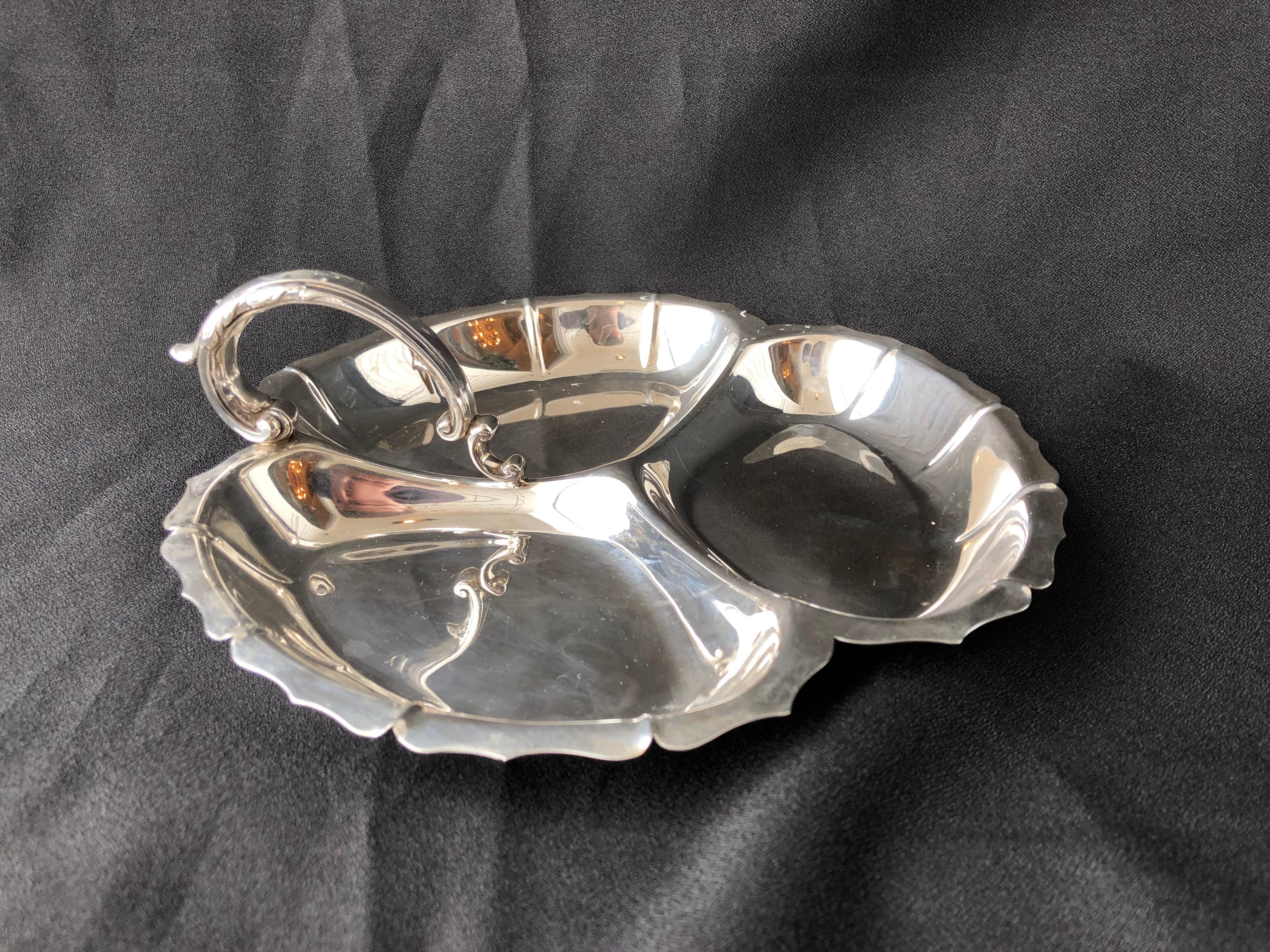 Handsome midcentury Georg Jensen tray

Scalloped edge, scroll for, handle 

Stamped George Jensen Inc, USA

Sterling 927

228 grams 

Measures: 3