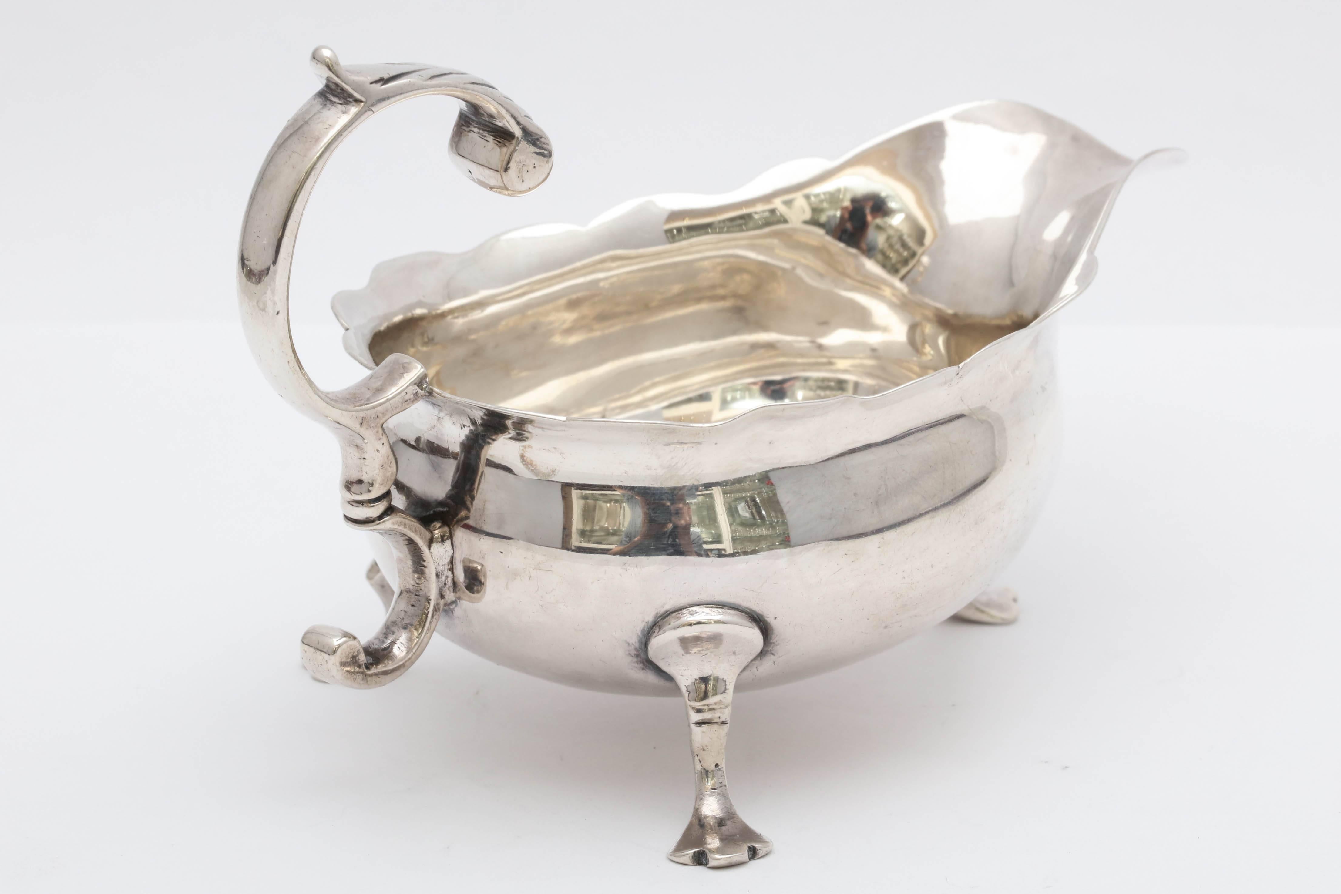 Sterling silver, paw-footed, Georgian - George II - sauce/ gravy boat, London, 1753. Measures 5 inches (from edge of handle to edge of spout) x 3 inches deep at deepest point (from back foot to back foot) x 3 1/4 inches high at highest point. Weighs
