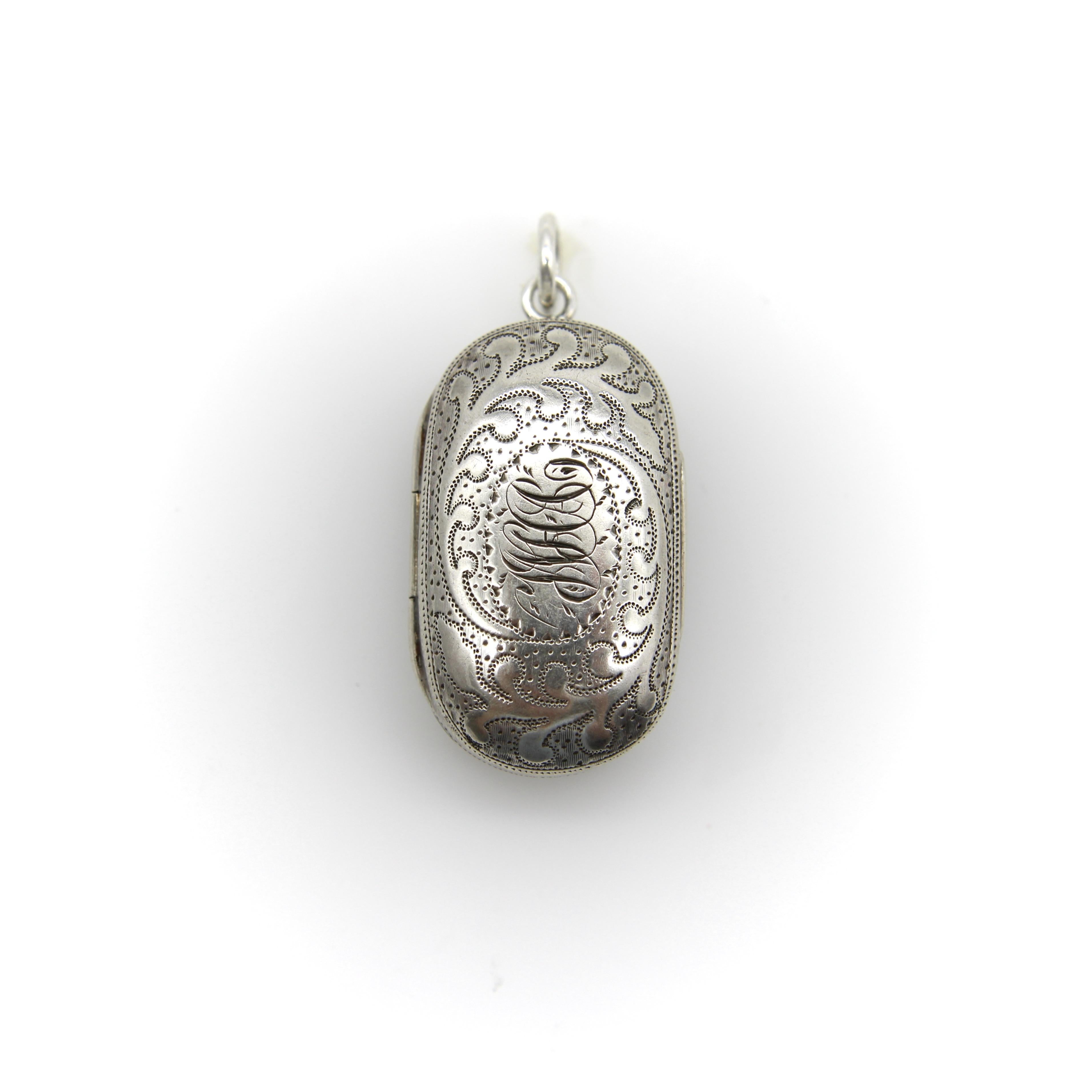 Questa vinaigrette georgiana in argento sterling ha una forma oblunga ed è incisa con un disegno fogliare e il monogramma 