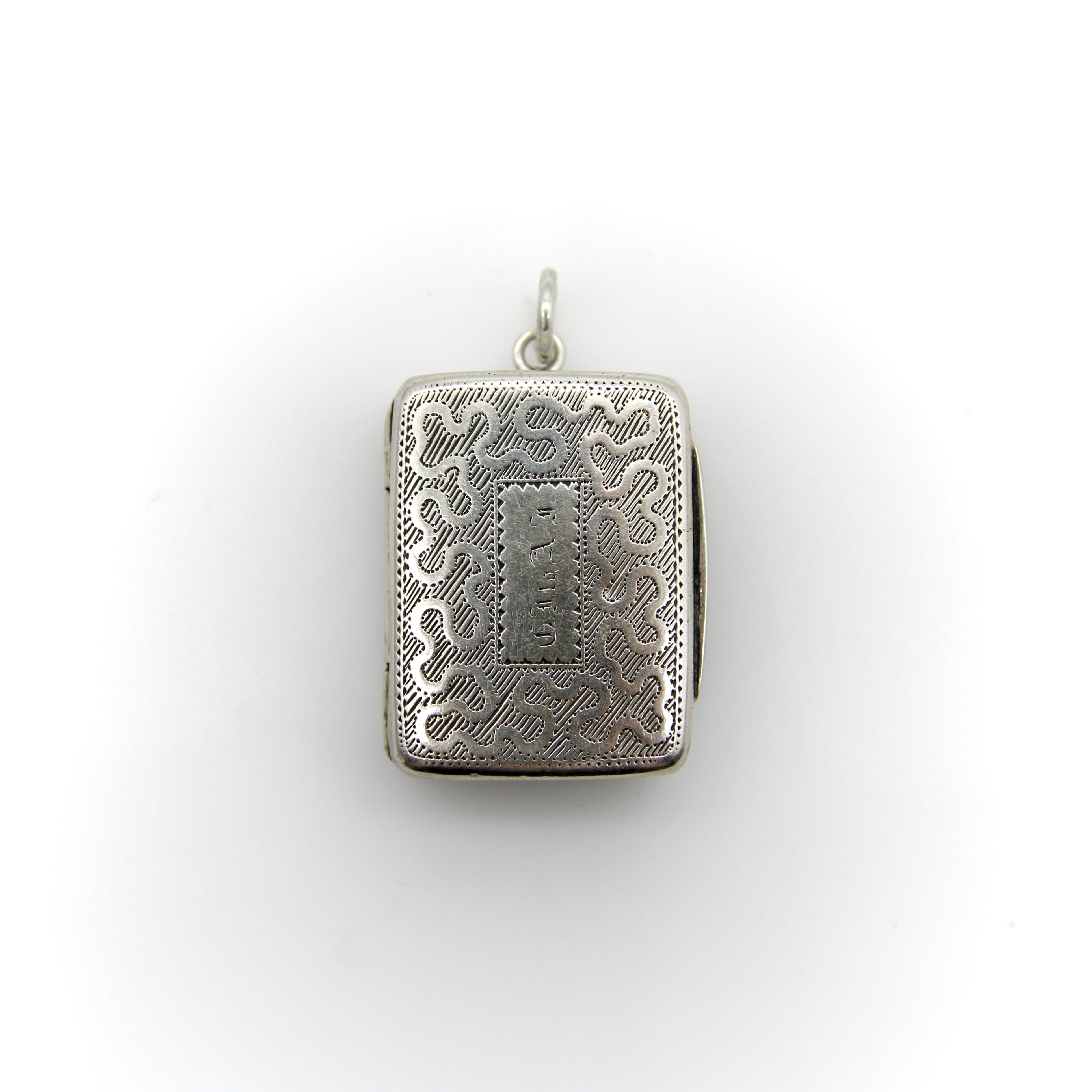Esta vinagrera georgiana de plata de ley tiene forma rectangular con un dibujo grabado que serpentea por la superficie de la tapa. El dibujo serpenteante se retuerce y gira de forma casi orgánica, con líneas grabadas detrás que hacen que el dibujo