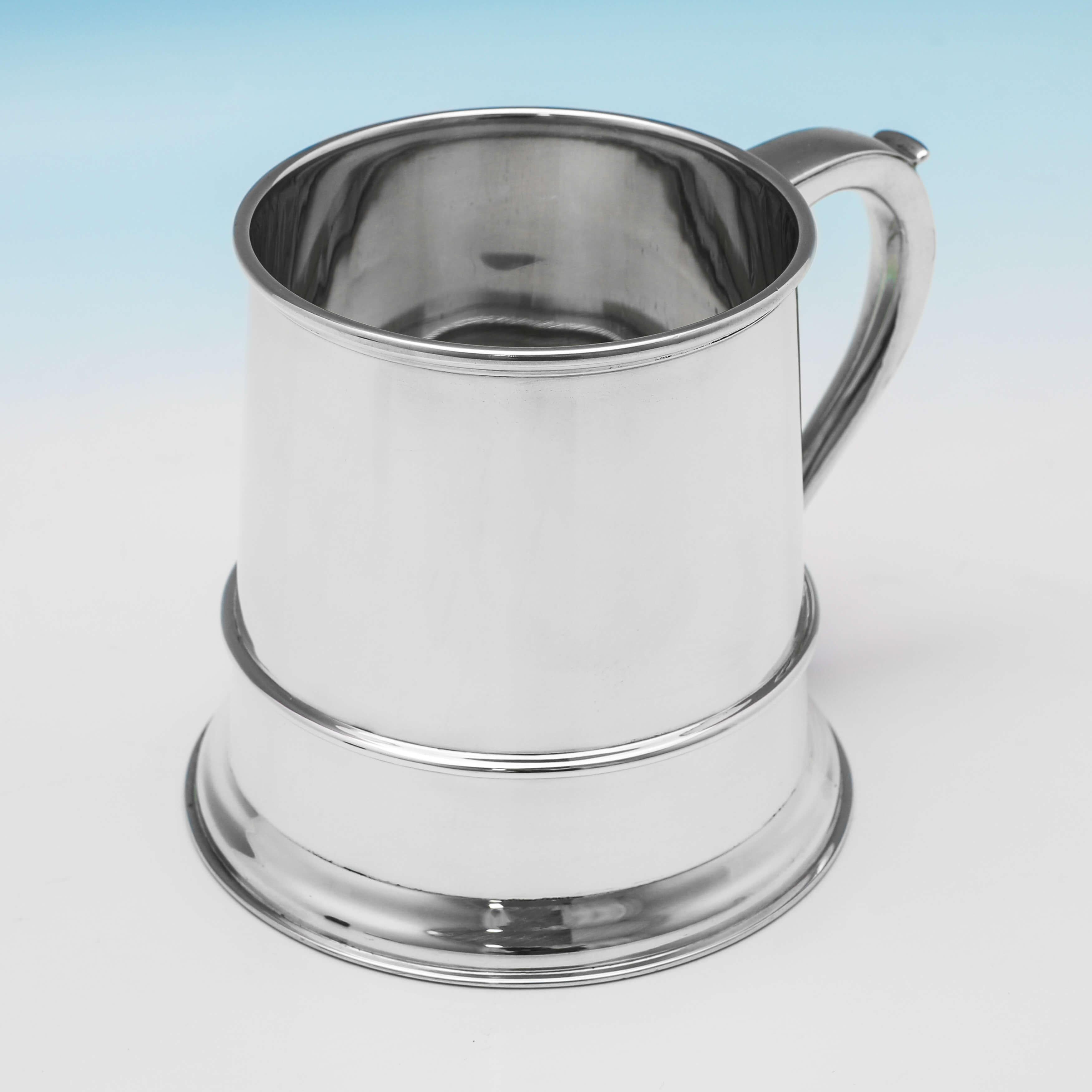 Hallmarked in London in 1942 by Goldsmiths & Silversmiths Co., this handsome, sterling silver mug, is straight sided, and features a glass base. The mug measures: 4