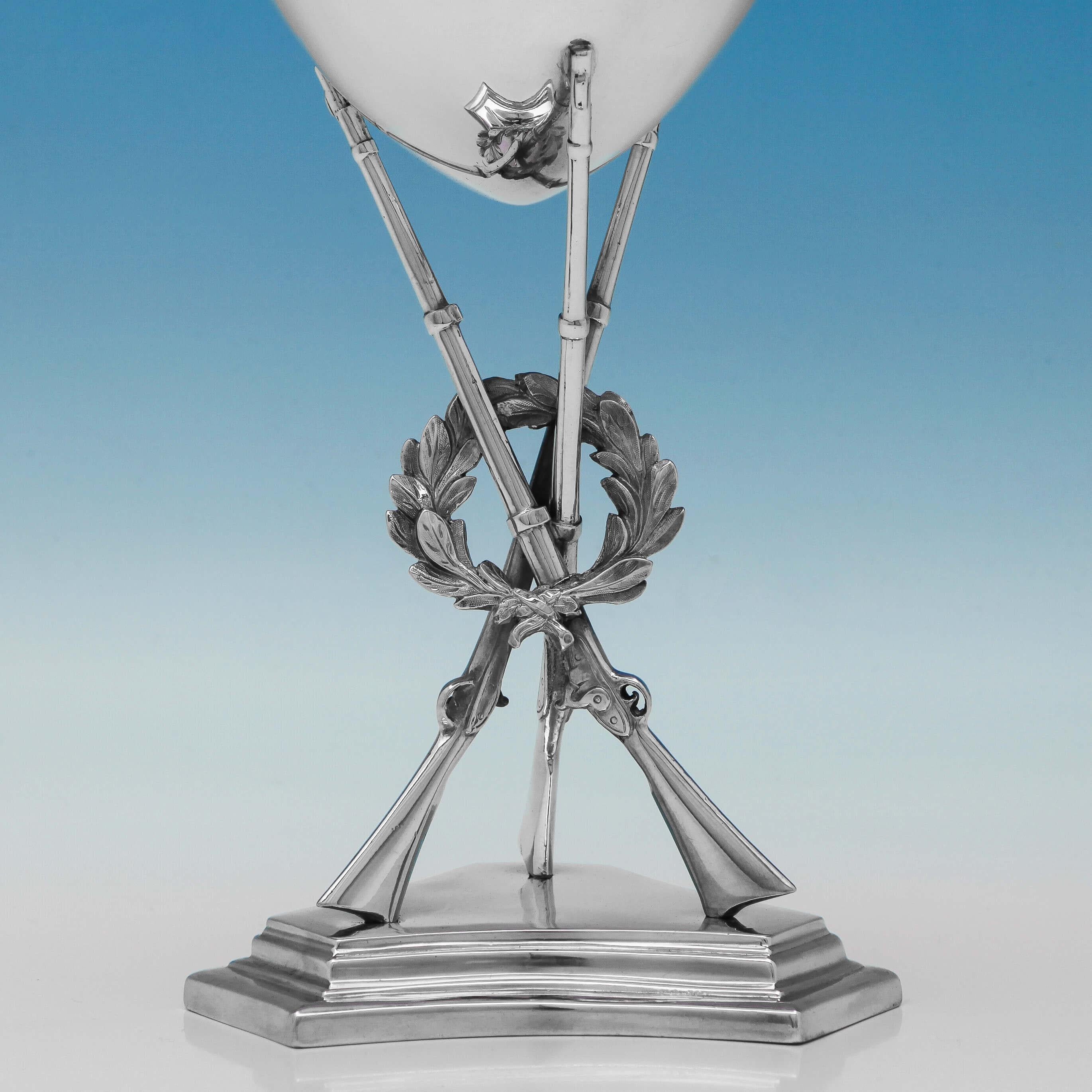Hallmarked in London in 1863 by George Angell, this fine antique, Victorian, sterling silver goblet would make an ideal presentation piece. It stands on a stepped pedestal base, with three rifles and a wreath forming the stem. It measures 9