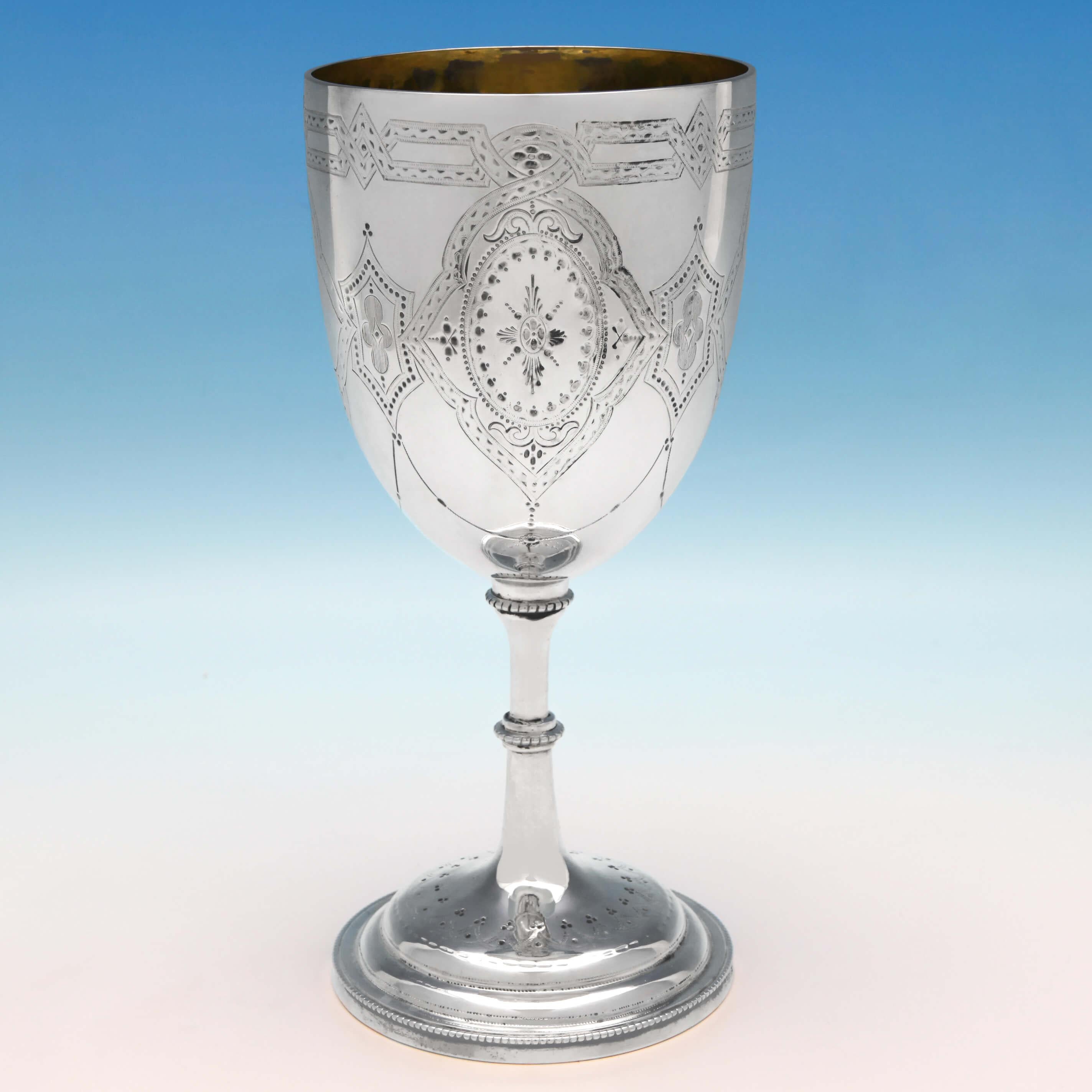 Hallmarked in London in 1869 by Henry Holland, this stylish, large, Victorian, antique sterling silver goblet, features attractive brightcut engraved decoration, bead borders and a gilt interior. The goblet measures 8.25