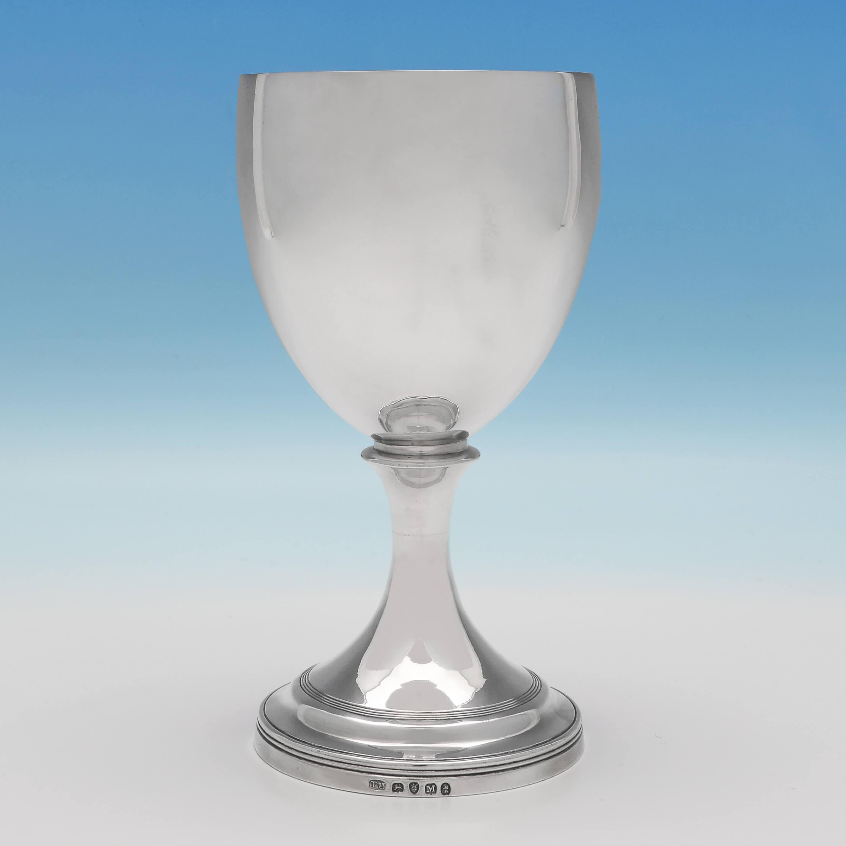 Hallmarked in London in 1807 by Thomas Holland II, this elegant, George III, antique sterling silver goblet, is plain in style, featuring reed detailing around the base and a gilt interior. The goblet measures 7