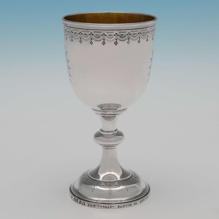 Hallmarked in London in 1870 by Robert Garrard, this attractive, Victorian, antique sterling silver goblet, features engraved decoration and a gilt interior. The goblet measures 6.25