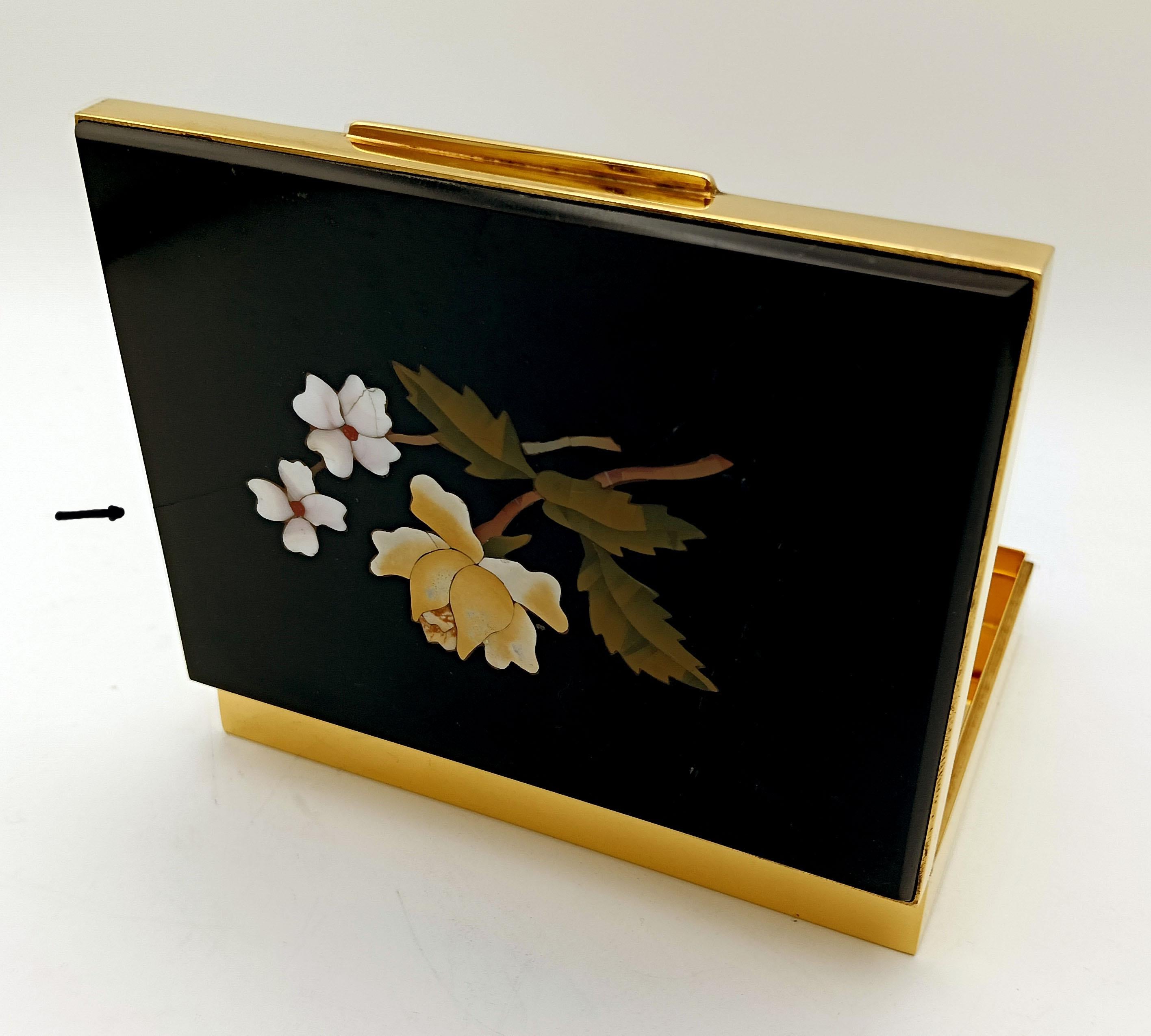 Etui à cigarettes de table rectangulaire en argent 925/1000 plaqué or, lisse sur les côtés. Le couvercle présente une plaque avec une fine mosaïque florale de pierres semi-précieuses réalisée selon la technique du 