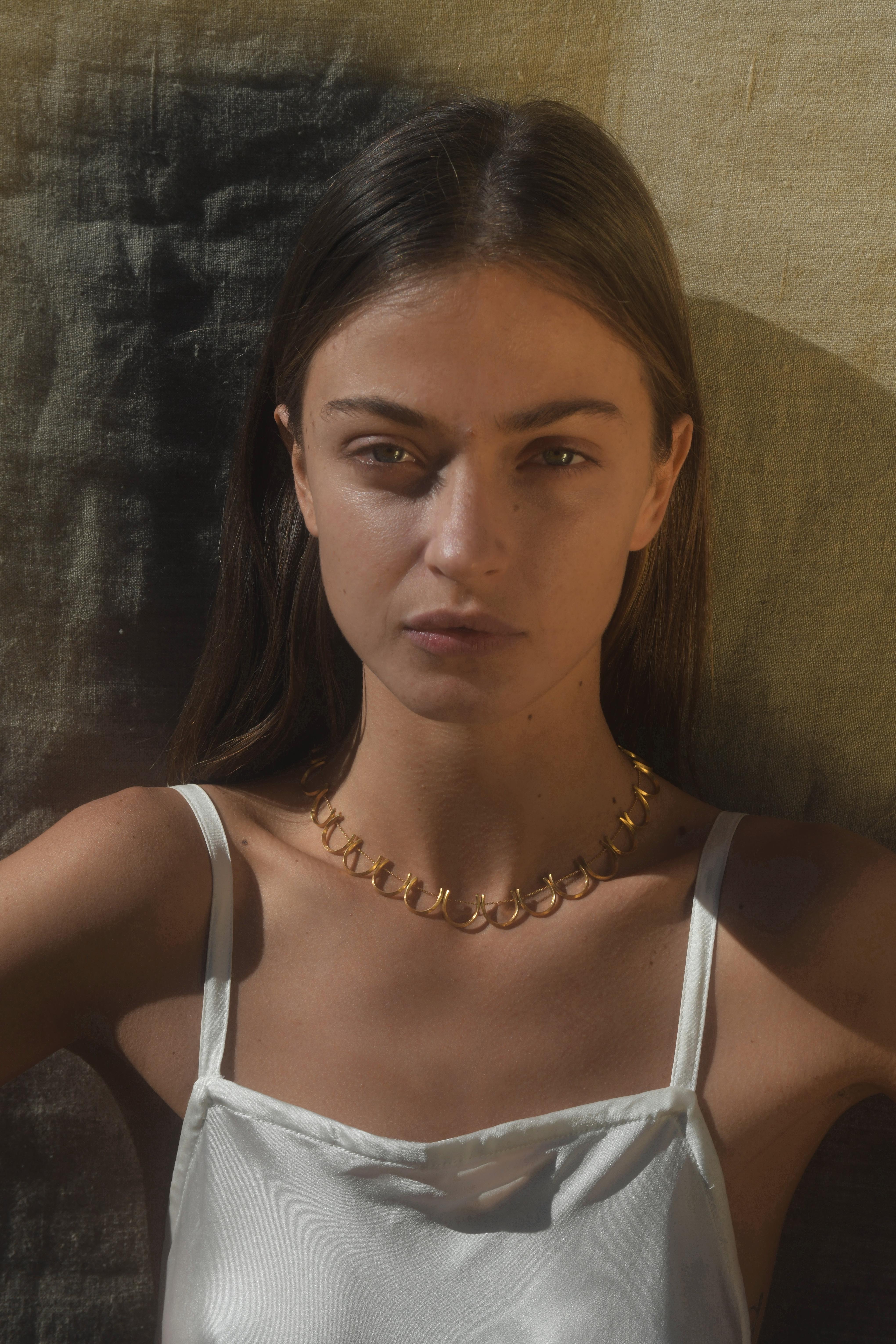 Timeless sterling silver 18k-gold plated necklace featuring round petal shaped motifs that go all around the neck. Every motif has been individually hand-crafted, finished and threaded to the chain by local skilled Greek craftsmen.

This piece is