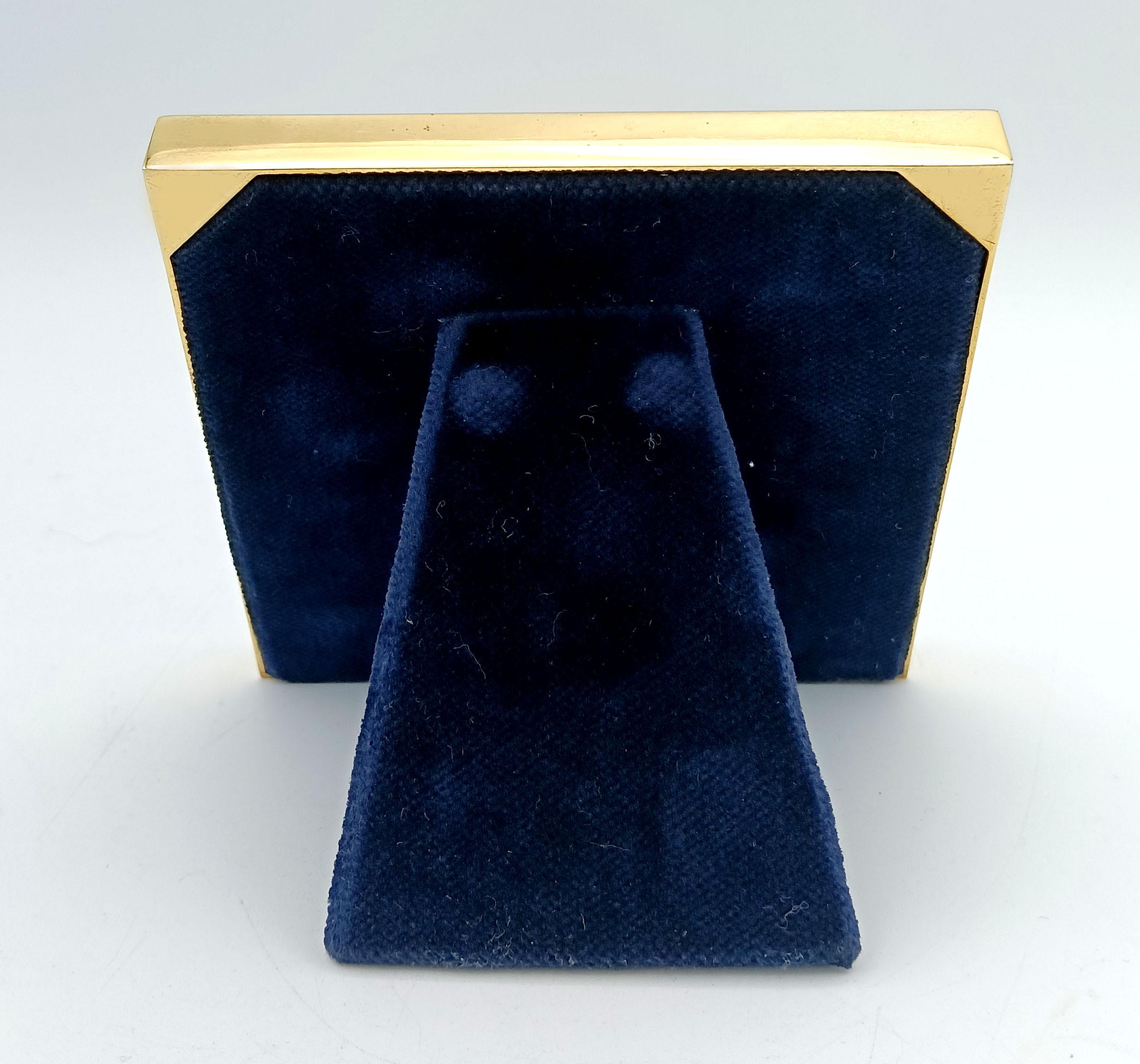  Cadre photo carré en argent 9251000 plaqué or avec émail cuit translucide sur guilloché. Style moderne et contemporain. Verre coupé. Panneau en velours bleu. Dimensions extérieures 10 x 10 cm, intérieures 7 x 7 cm. Poids 107 g. Conçue par Renato