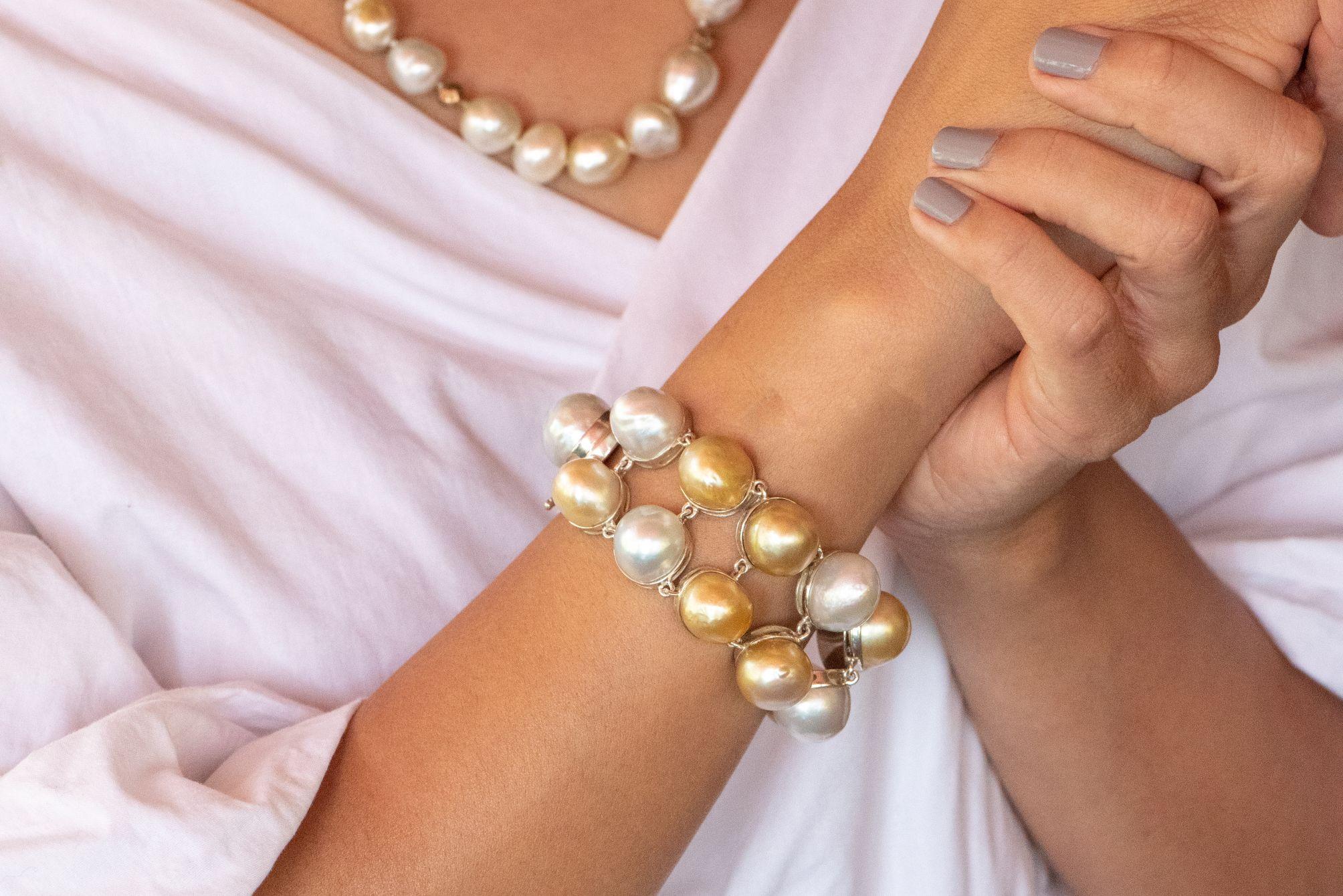 Sparkling white and deep gold 12 to 17 mm baroque south sea pearls jostle for attention in this gorgeous 19.2 by 3.5 cm sterling silver bracelet