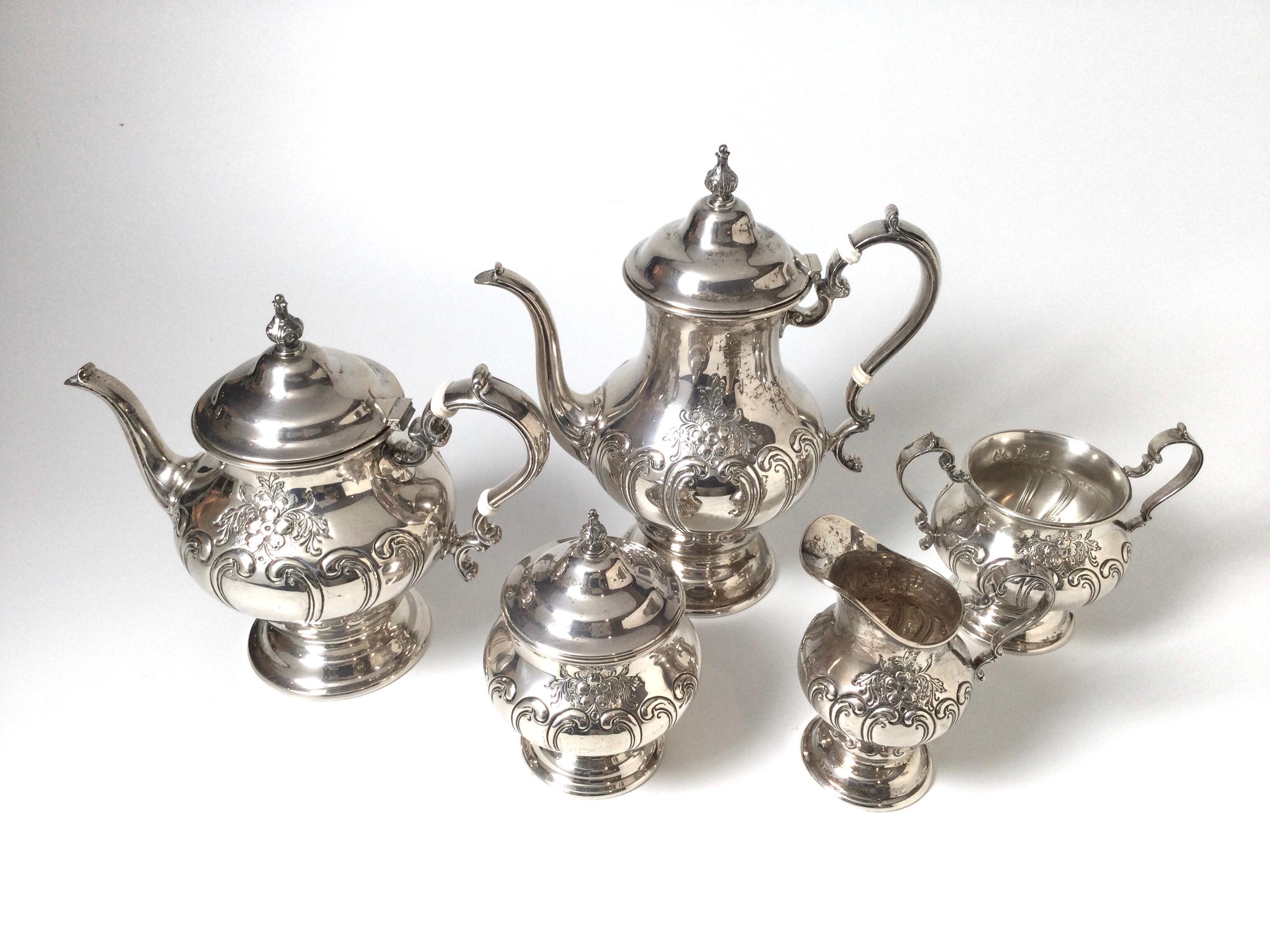 Sterling silver tea service with coffee pot, 11 inches, tea pot 9 inches, waste bowl 5.5 inches, covered sugar 6.25 inches, and creamer, 5.5 inches. The set with an all over repoussé decoration. The pattern is Chantilly mid 20th Century, This set is