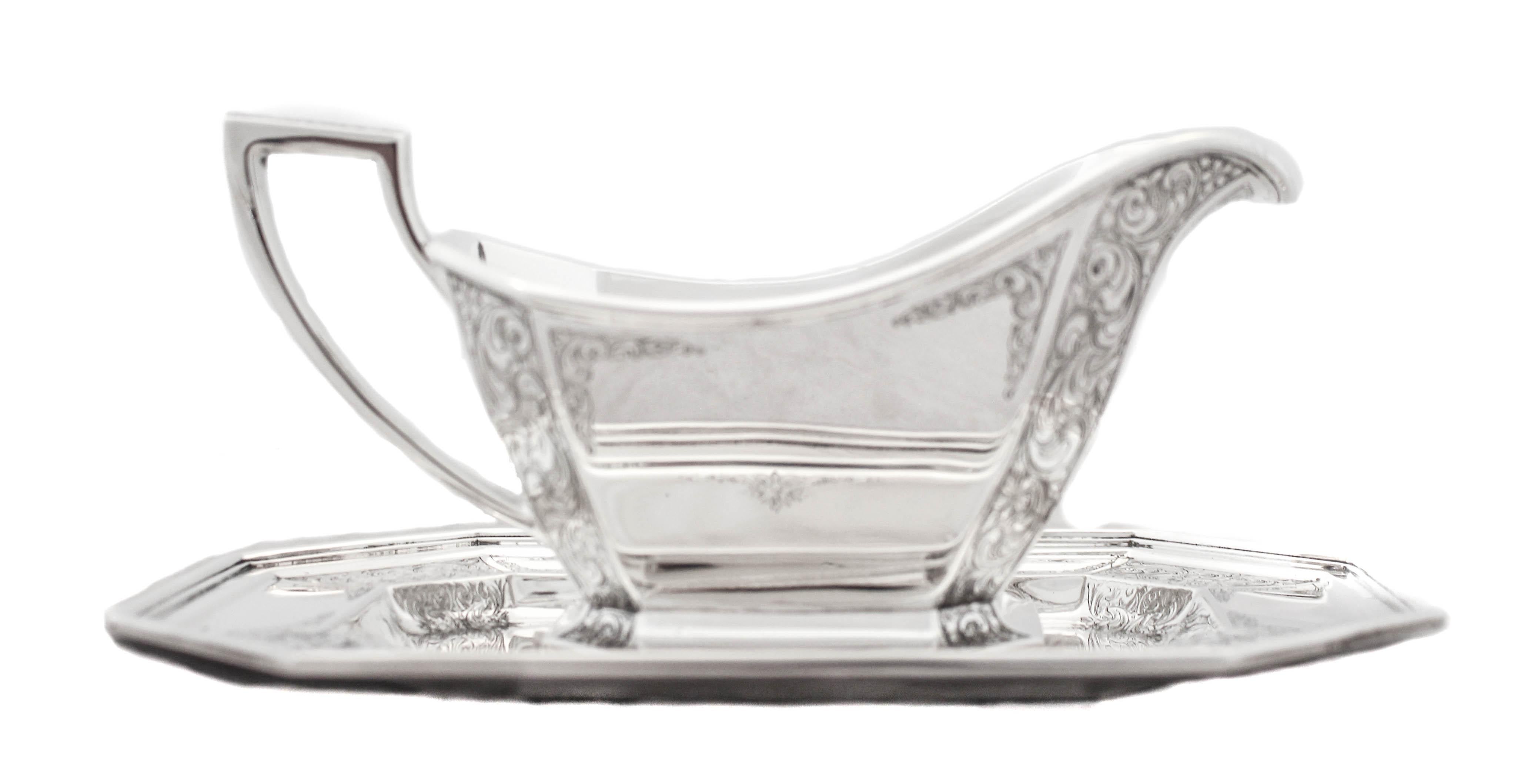 Being offered is a sterling silver gravy boat and tray by William Durgin Silversmiths in the Fairfax pattern. 
It has etching on the handle as well as on the corner panels — both on the boat and tray. Both pieces are eight sided (polygon) which is