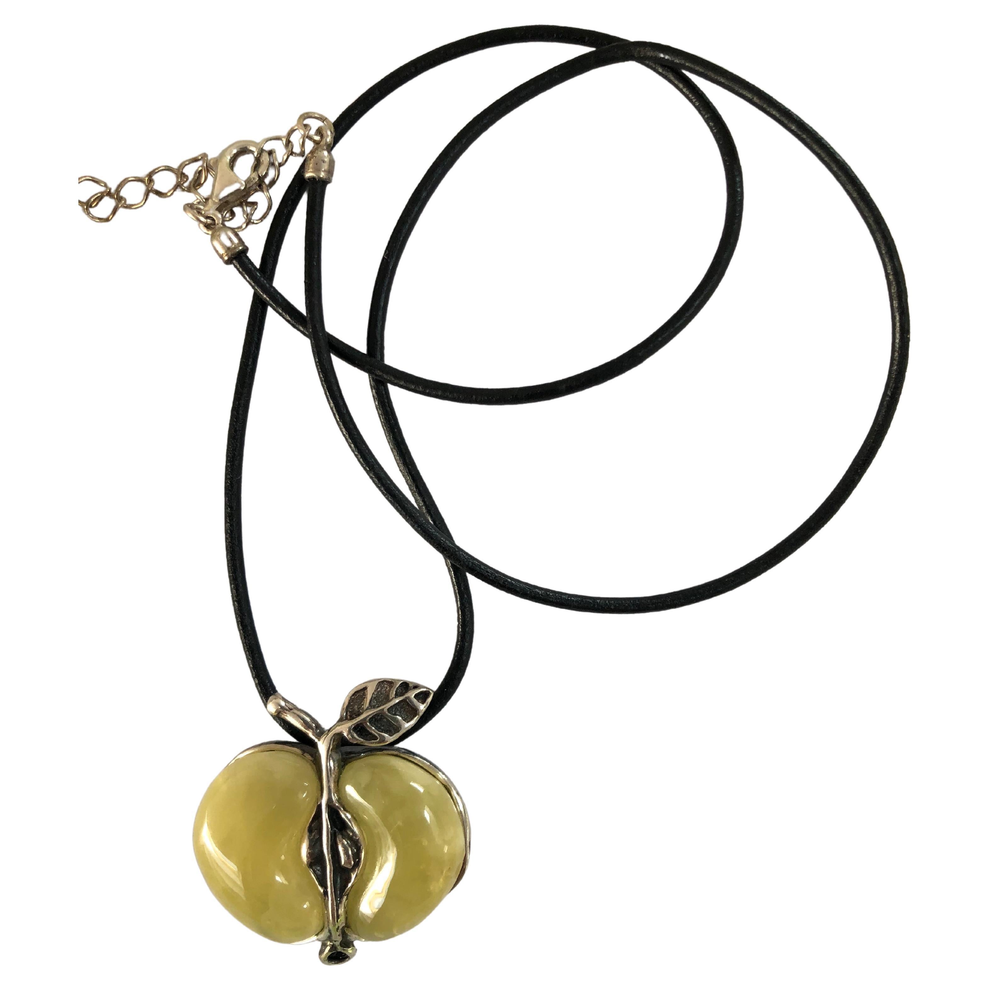 Unique handmade amber and sterling silver 925, pendant necklace on leather strap with sterling clasp. The light green milky amber is apple-shaped delicately set in sterling silver. Strap length about 19 inches.