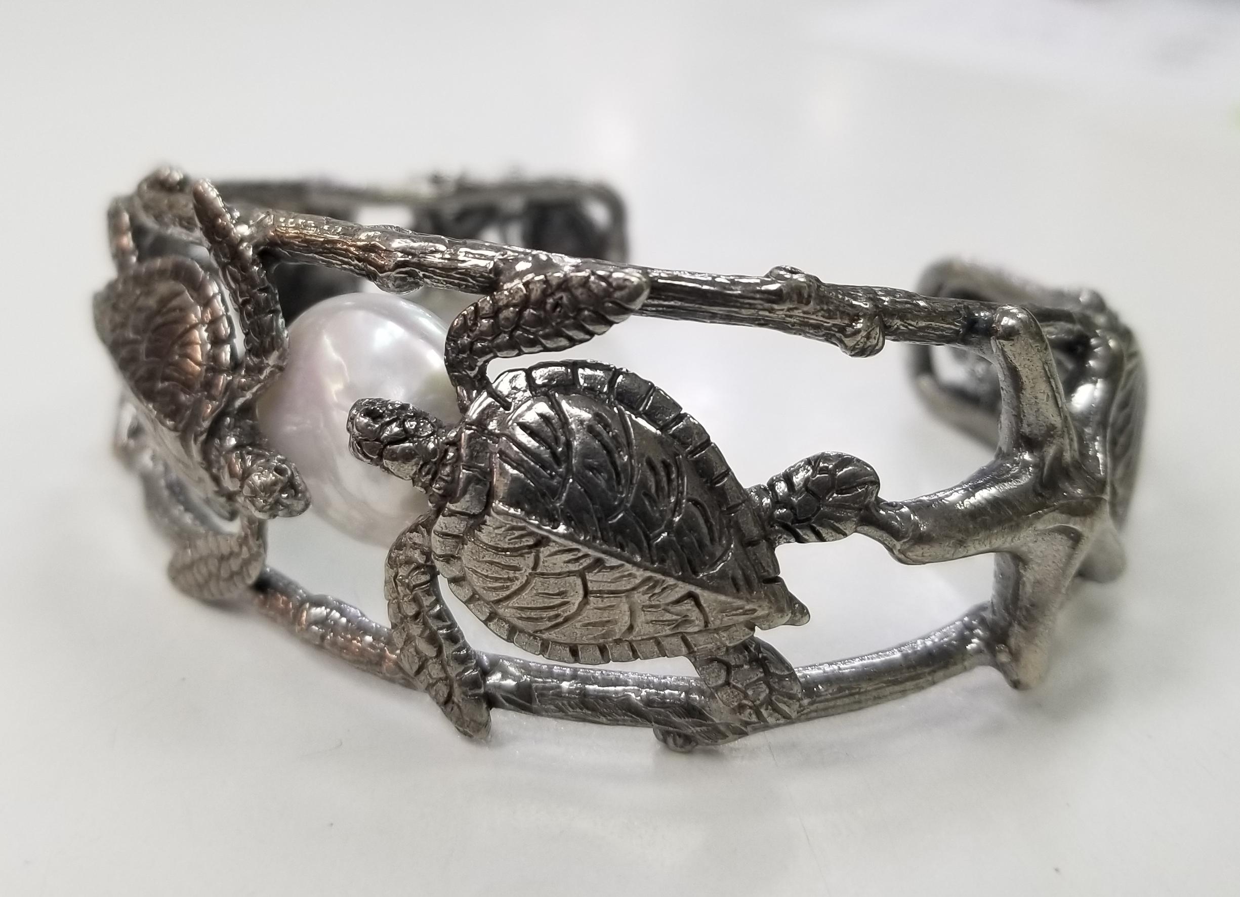 Sterling silver Gresha signature bark, turtle and shell with a pearl.   The silver has been black rhodium for antiquing. 
*this design is ours and can be created in any other form; ring, necklace, bracelet, or earrings*