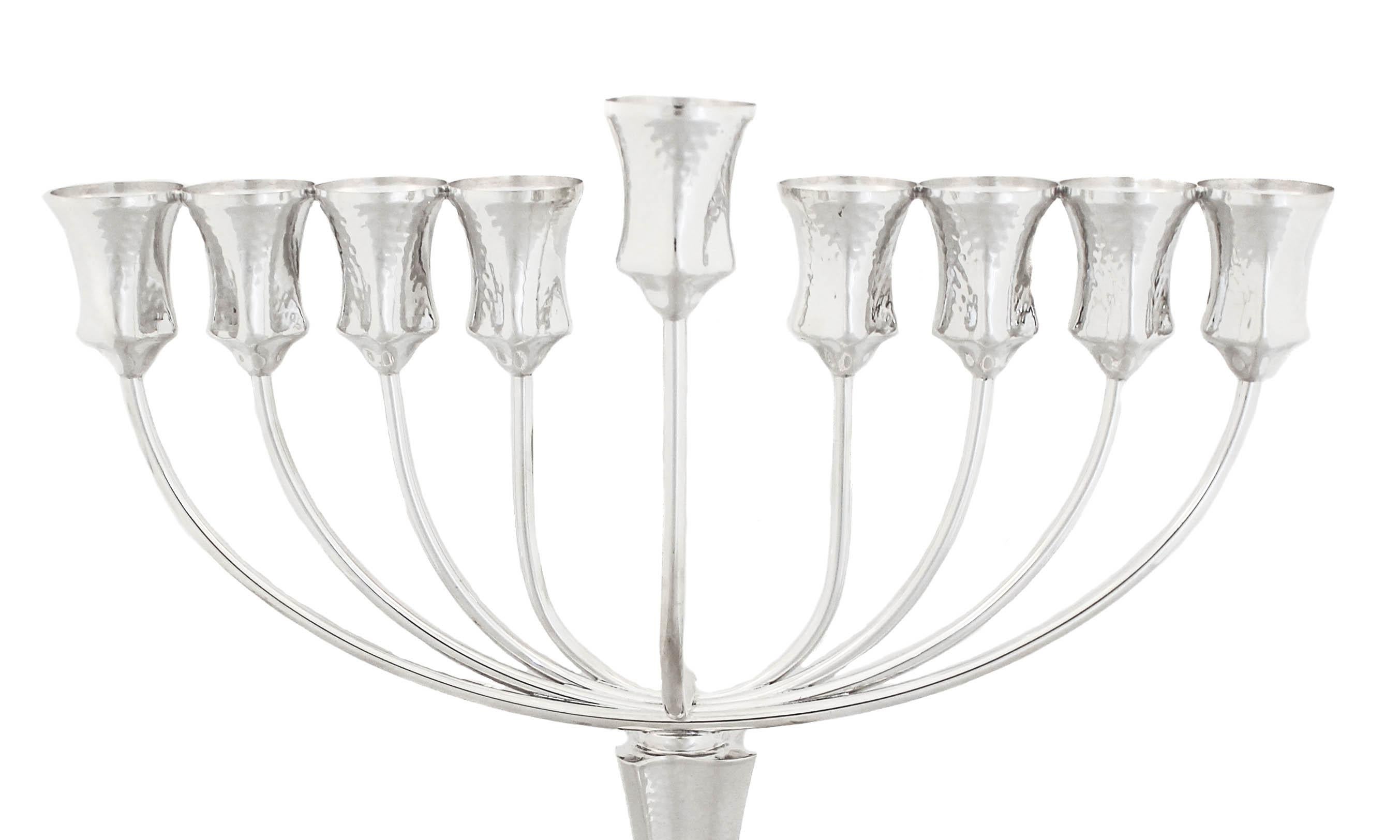 Being offered is a new sterling silver menorah made in Israel.  It has a hammered finish with a swirl base and square shape cups.  The menorah unscrews in the center — where the pedestal meets the top for easy storage.  A beautiful modern piece to