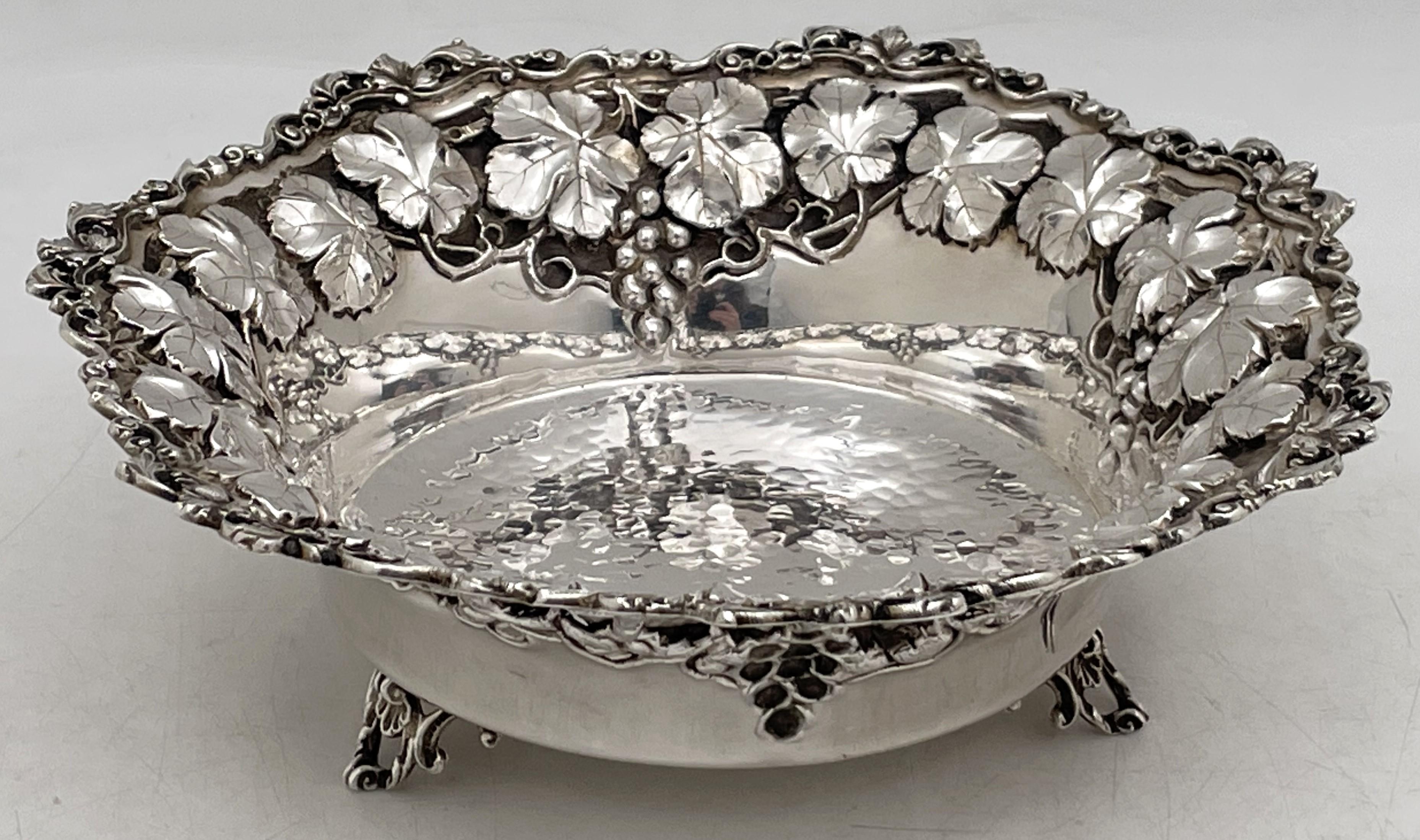 Sterling silver, hammered 20th century bowl with repousse leaves and vine motifs, standing on 3 feet. It measures 8 1/3'' in diameter by 2 1/2'' in height, weighs 9.8 troy ounces, and bears hallmarks as shown. 

Please feel free to ask us any