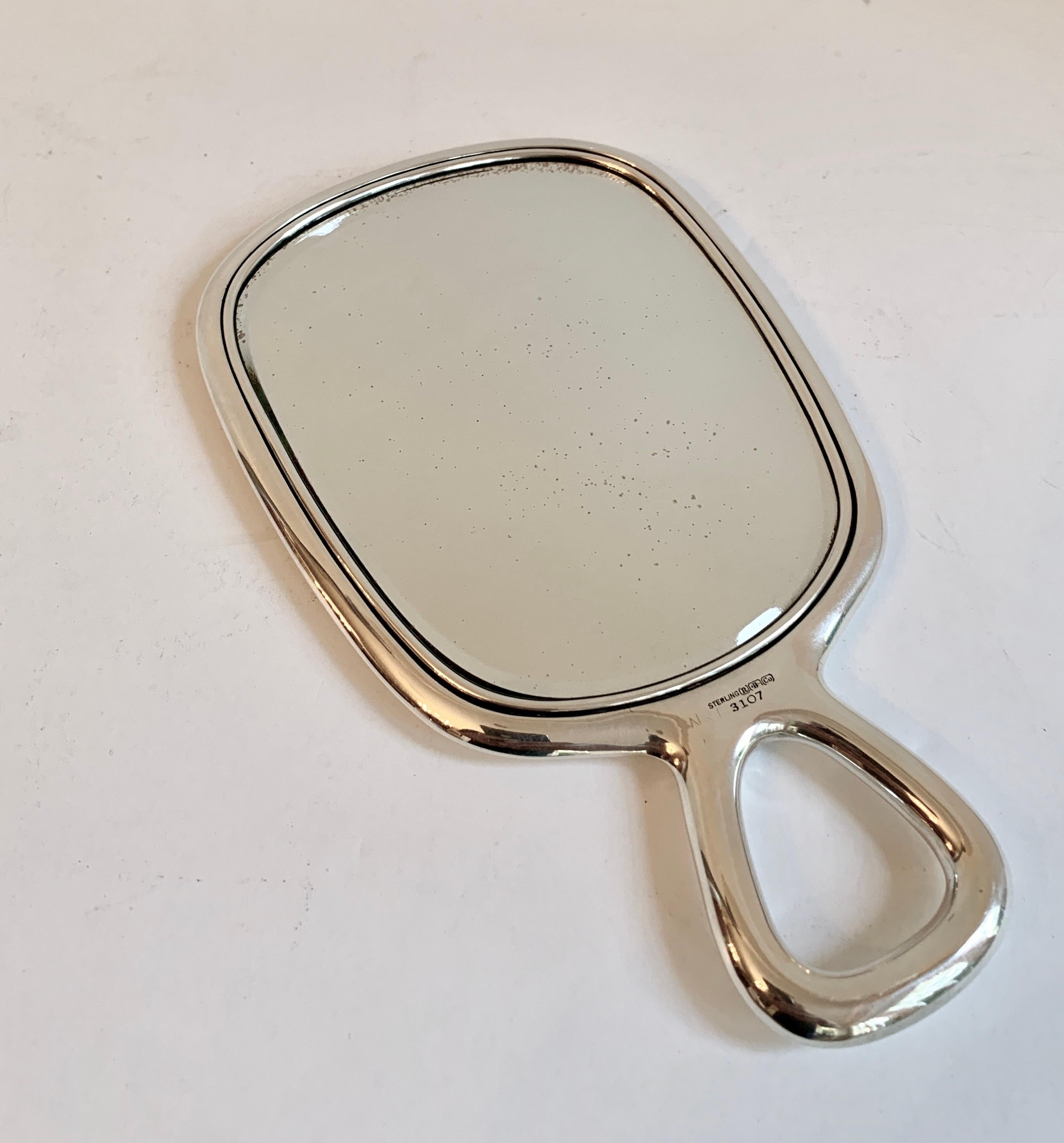 A lovely sterling silver hand mirror. The handle is a compliment to most styles as it is clean, simple and architectural.

We found this to be just the right size for the vanity or dressing table or the guest room. While the mirror and glass do