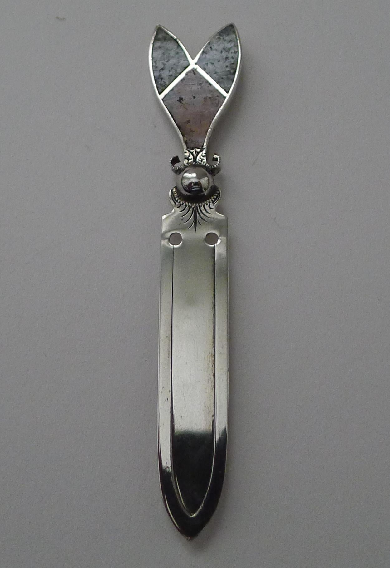 A handsome little bookmark made from sterling silver (marked Sterling), the terminal inset with red and green hardstones.

The silver is signed by the Birmingham silversmith, Joseph Cook & Son Ltd.  Dating to c.1910, it remains in excellent