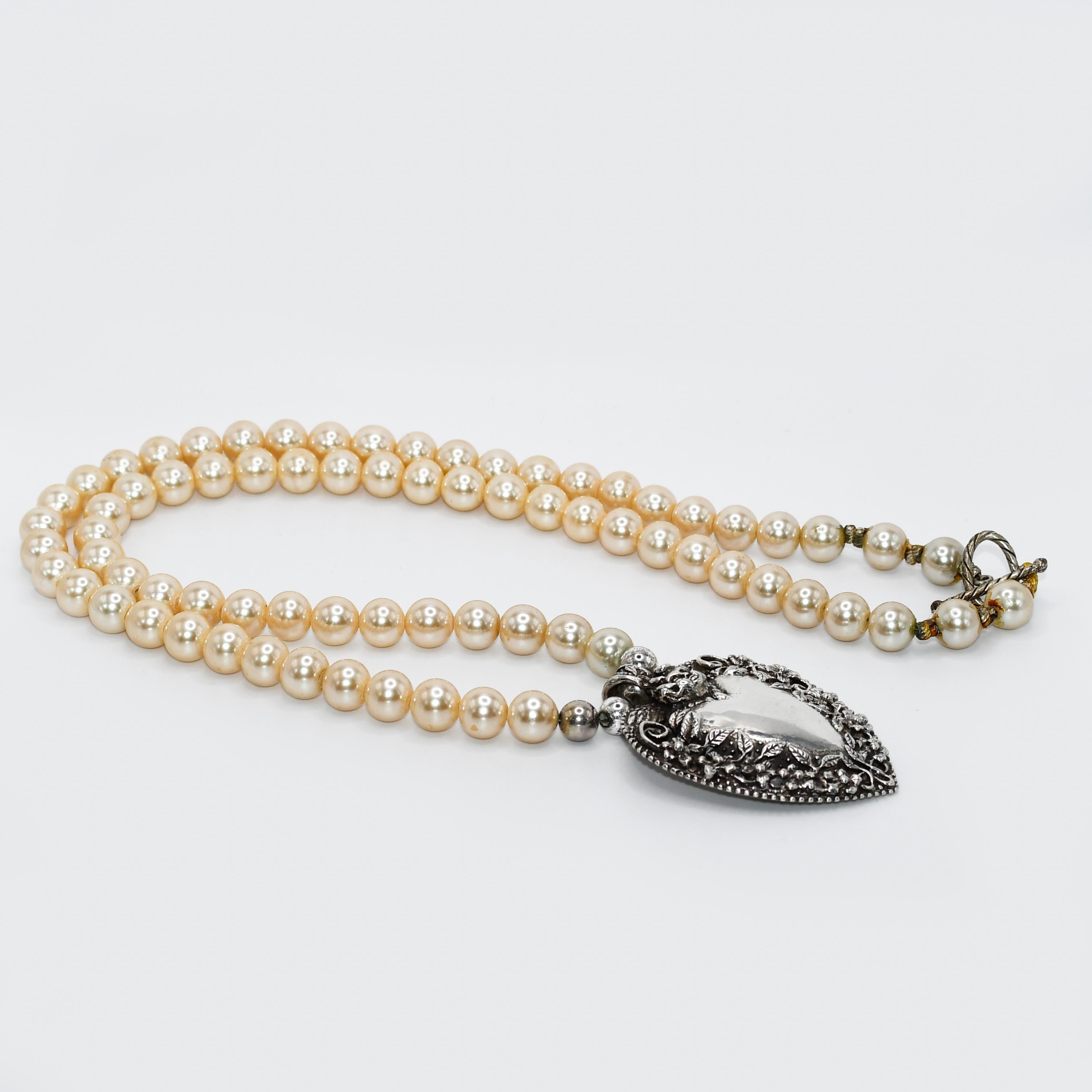 Sterling Heart Pendant, Faux Pearl Necklace, 158g
Designer silver and faux pearl necklace by Andrea Barnett.
The silver heart pendant is stamped .925 Andrea Barnett.
The sterling silver heart weighs 54 grams and measures 2 1/2 by 1 3/4 inches.
The