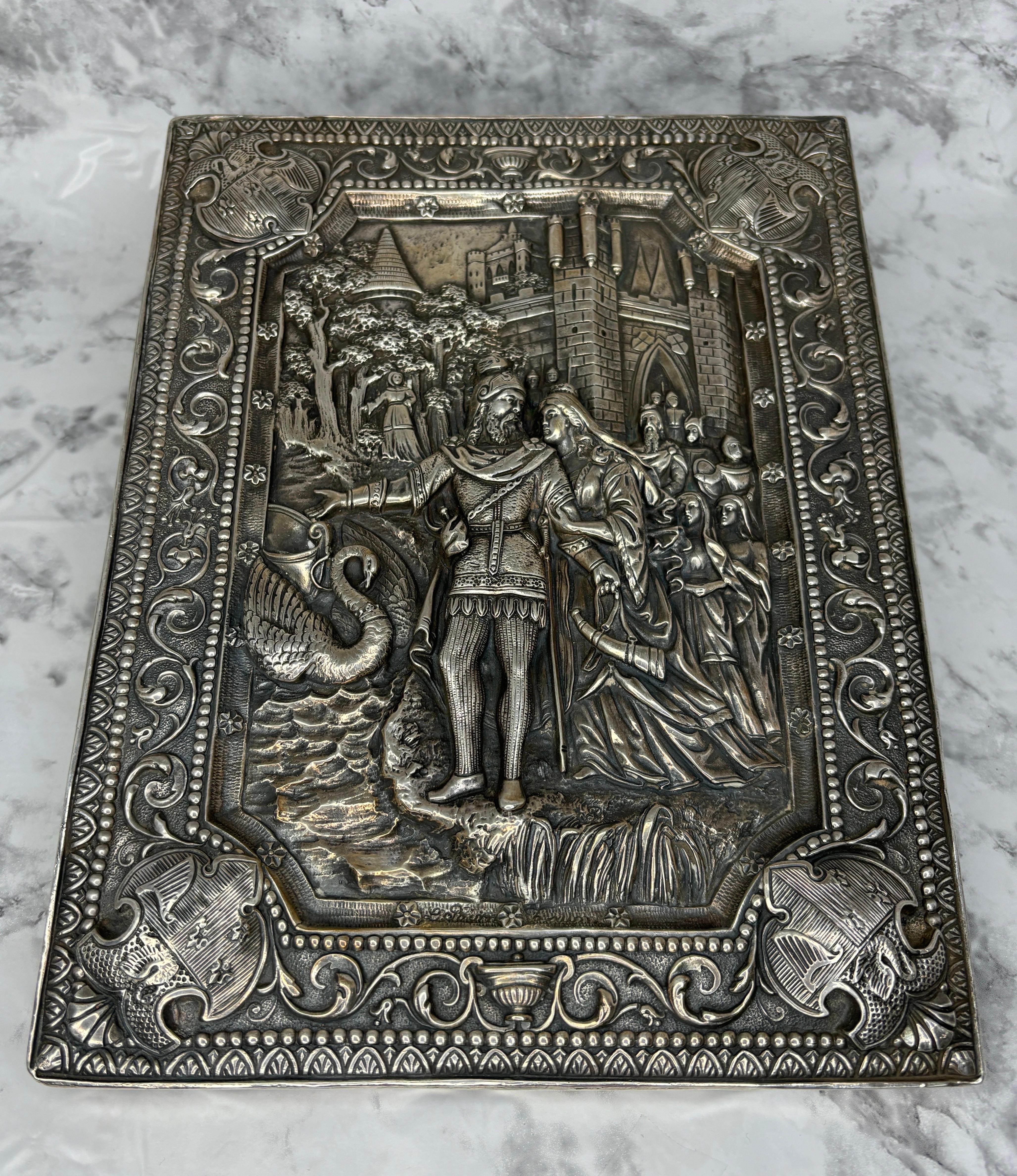 Una placca in argento sterling repousse finemente dettagliata con cavaliere, castello, stemma e cigno di Henryk Winograd.

Henryk Winograd è stato uno dei più grandi maestri del XX secolo delle tecniche tradizionali di argenteria ed è stato il