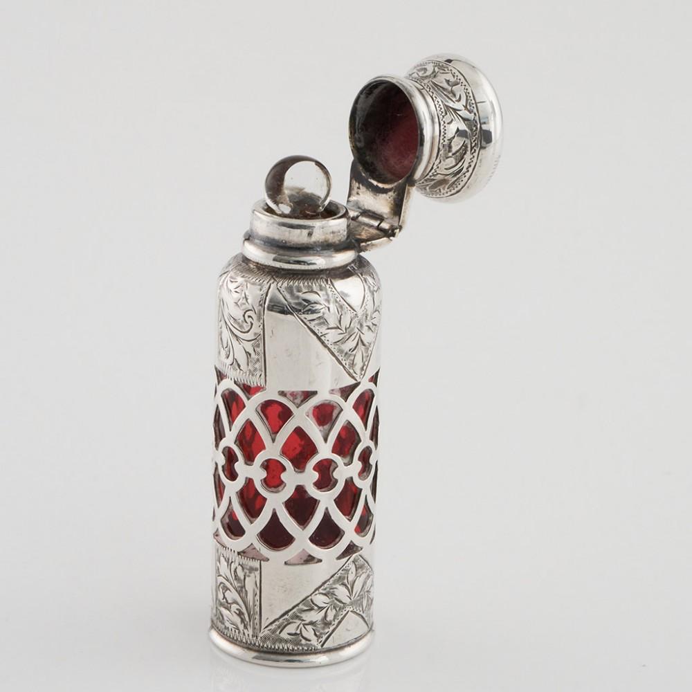 Heading : Sterling Silver Hinged Top and Ruby Glass Perfume Bottle Birmingham
Date : Hallmarked in Birmingham 1903 For Mr Cohen and Charles
Period : Edward VII
Origin : Birmingham England
Decoration : Chased floral and foliate chevrons and pillars.