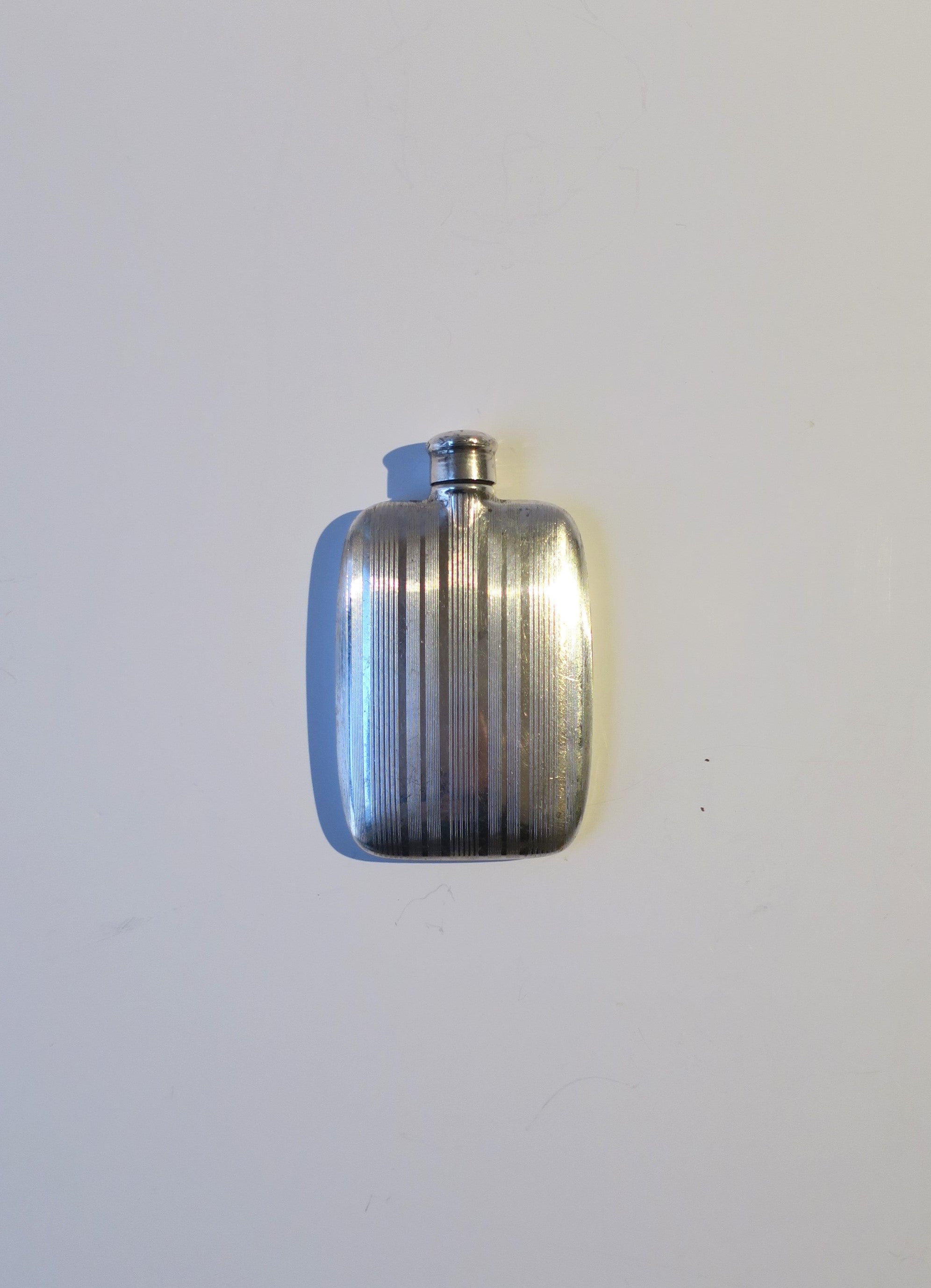 A beautiful small sterling silver hip or pocket flask, Art Deco period, made by Napier Co., circa early-20th century, Massachusetts, USA. Flask has engraved stripes down front and plain back (where an engraving or monogram may be added if so desired