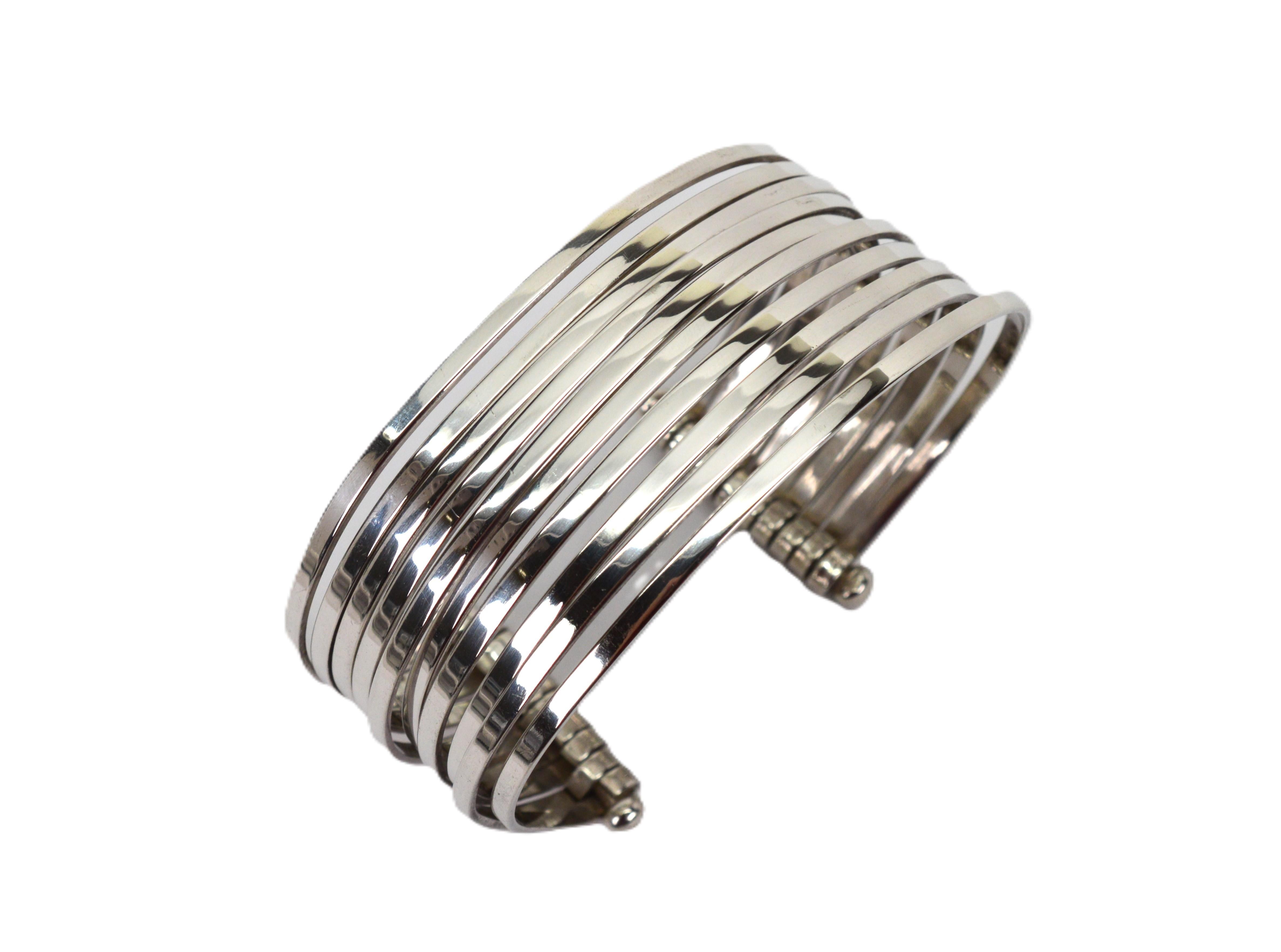 Ottieni il look impilato con un solo bracciale con questo bracciale multistrato in argento sterling. Dieci sottili 2,5 mm  Le bande d'argento sono sapientemente incernierate tra loro per creare un look multidimensionale di un pollice. Anche se