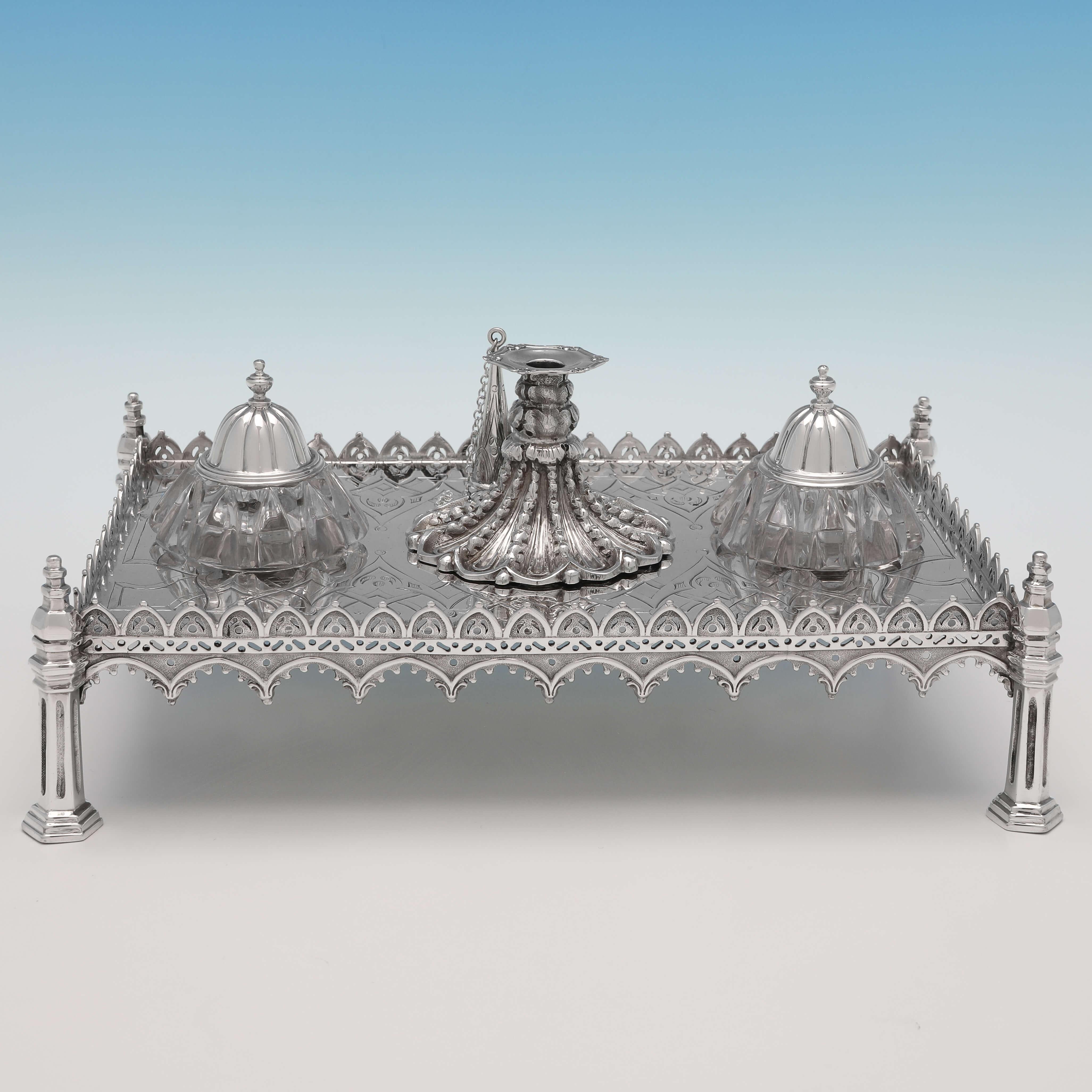 Hallmarked in London in 1843 by Joseph Angell & Son, this striking, Victorian, Antique Sterling Silver Ink Stand, is in the Gothic Revival taste, and features a central taper holder and two glass pots for ink. The ink stand measures 4.5