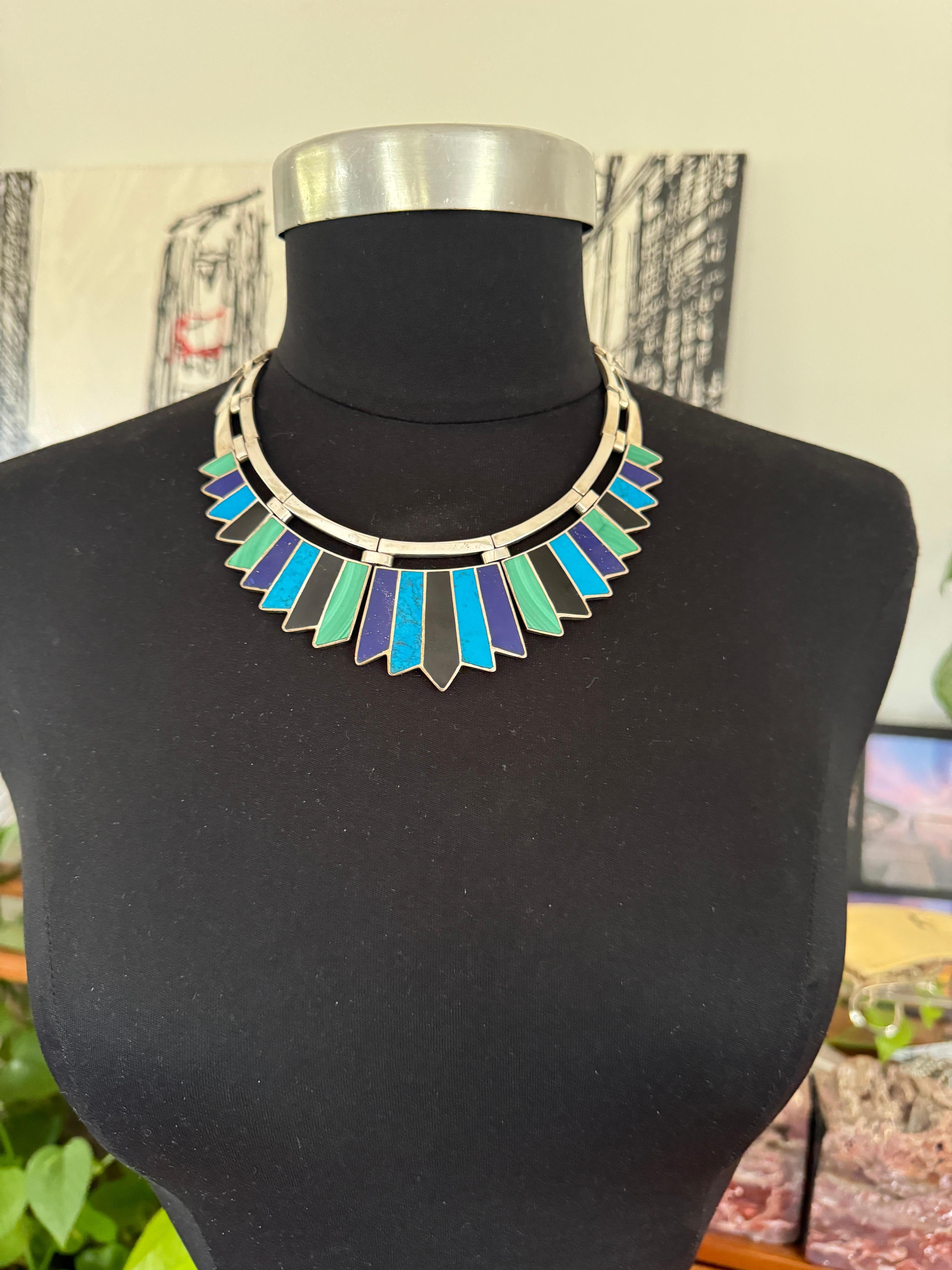 Un girocollo modernista messicano intarsiato molto speciale. Composta da onice nera, ostrica viola, turchese, malachite e lapislazzuli, collana Arrow Link stilizzata. Misure esterne: Misura interna: circa 15