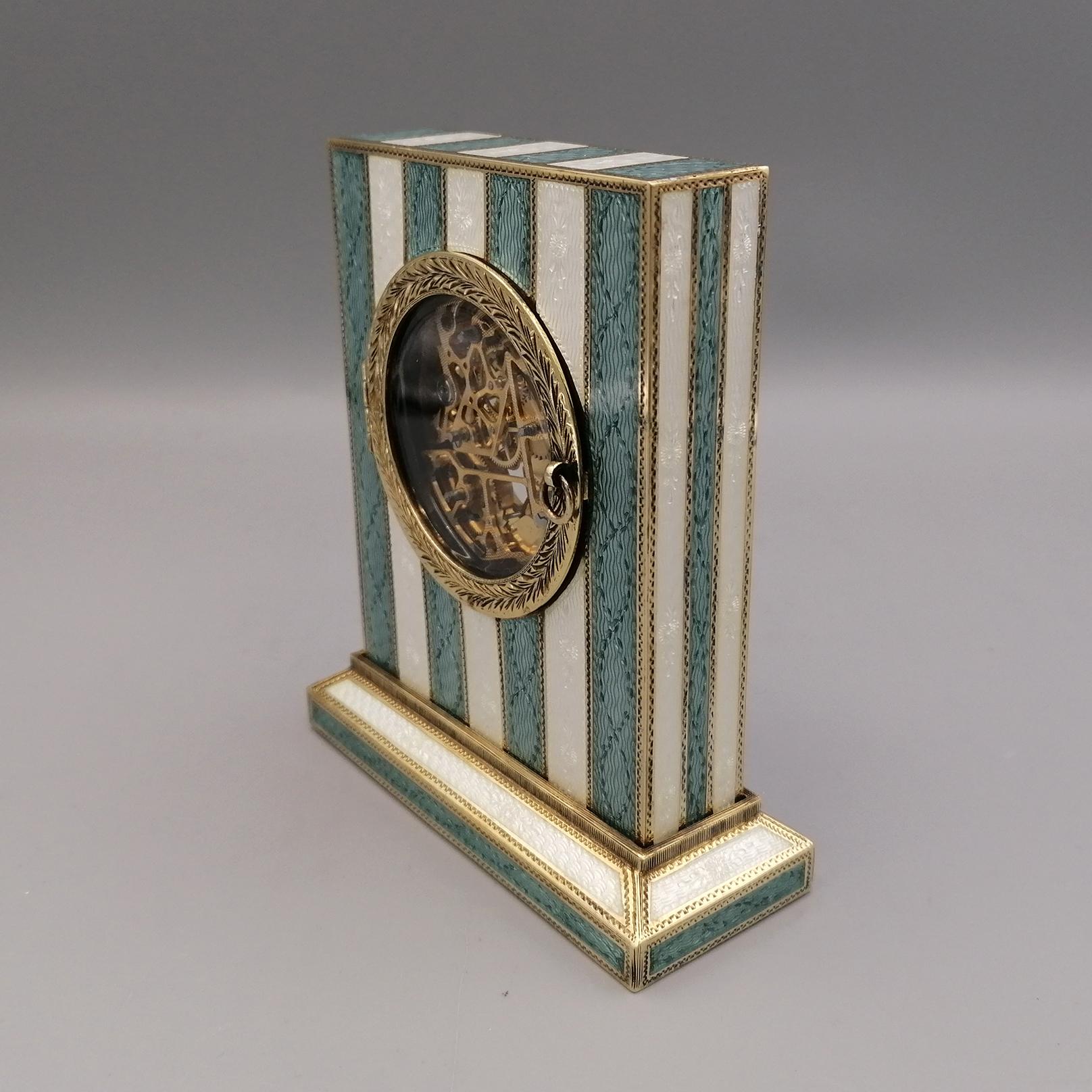 Silver table clock 925/1000 golden with translucent fire polishes in stripes on hand-engraved guillochè, Swiss mechanical skeletal movement 8 days

The miniatures are hand-painted on a usually white homogeneous enamel base. The same colored glazes