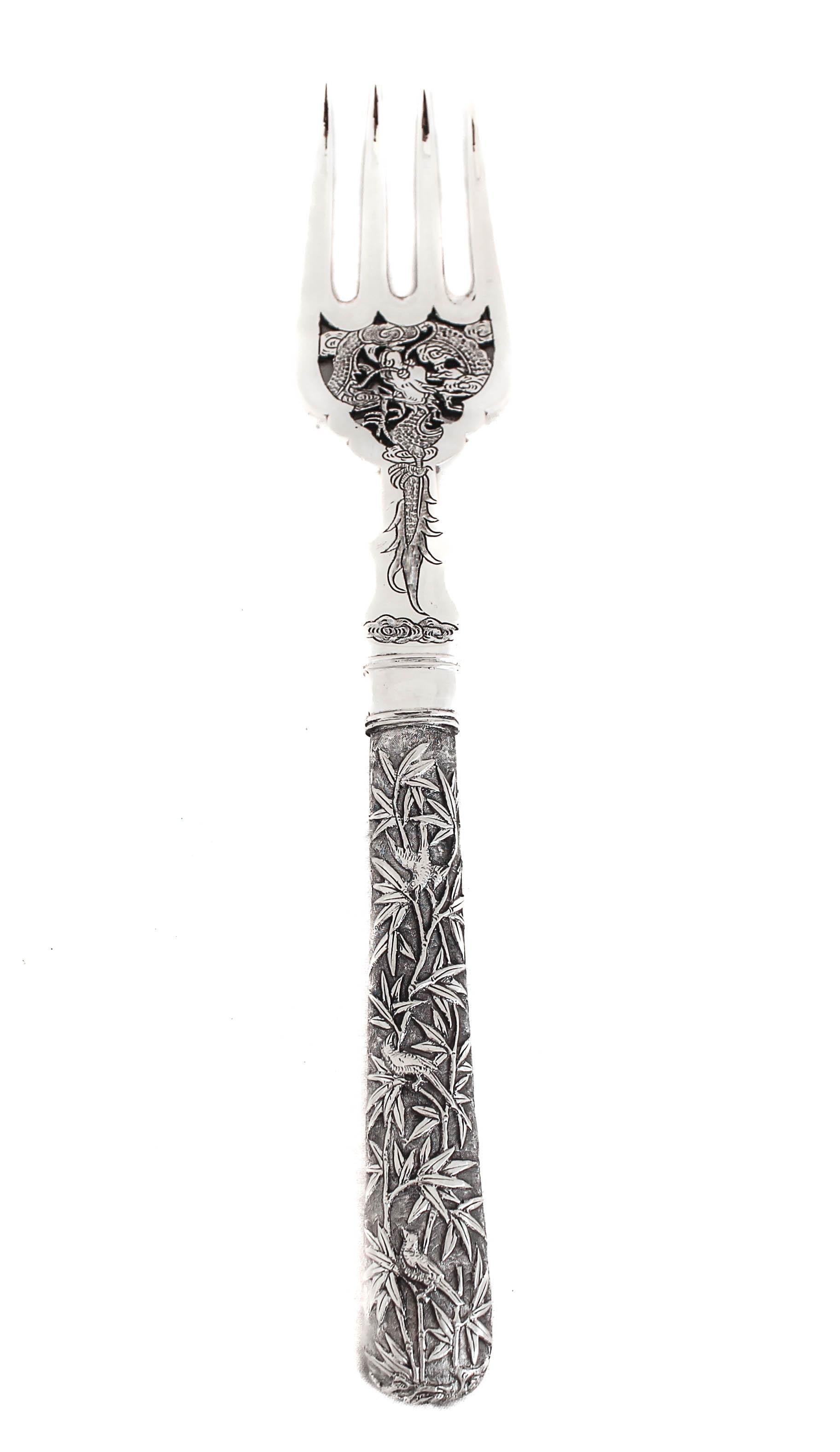 Being offered is an exquisite example of a Japanese sterling silver fish fork and server.  The handles on both pieces have a bamboo motif with birds on them.  The fork has an elaborate design between the handle and tines.  The server has a cutout