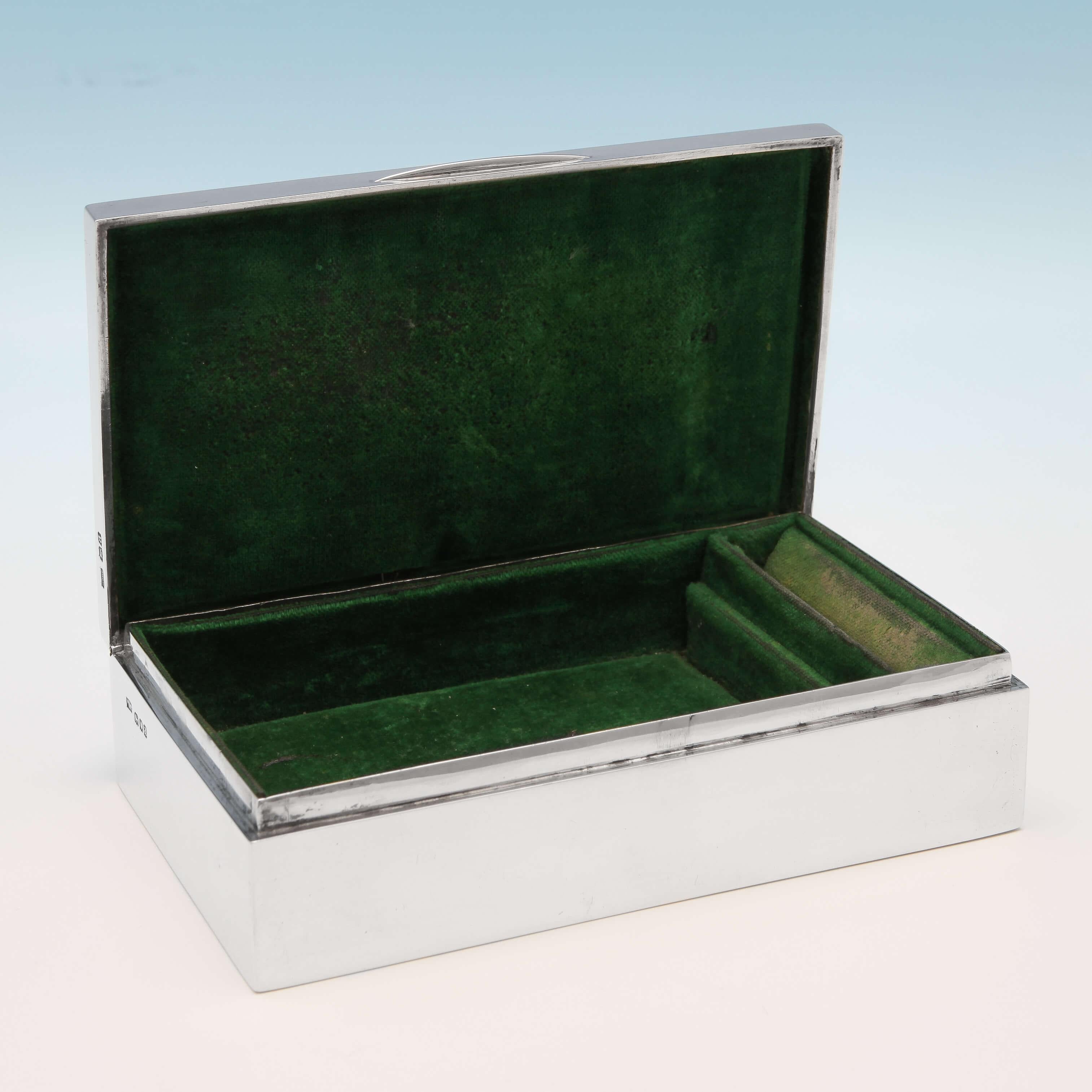 Hallmarked in London in 1916 by Mappin & Webb, this attractive, George V, sterling silver jewellery box, has a green velvet lining, with a slot for rings. The lid has been engraved with floral swag and scroll decoration and has a bird in flight at