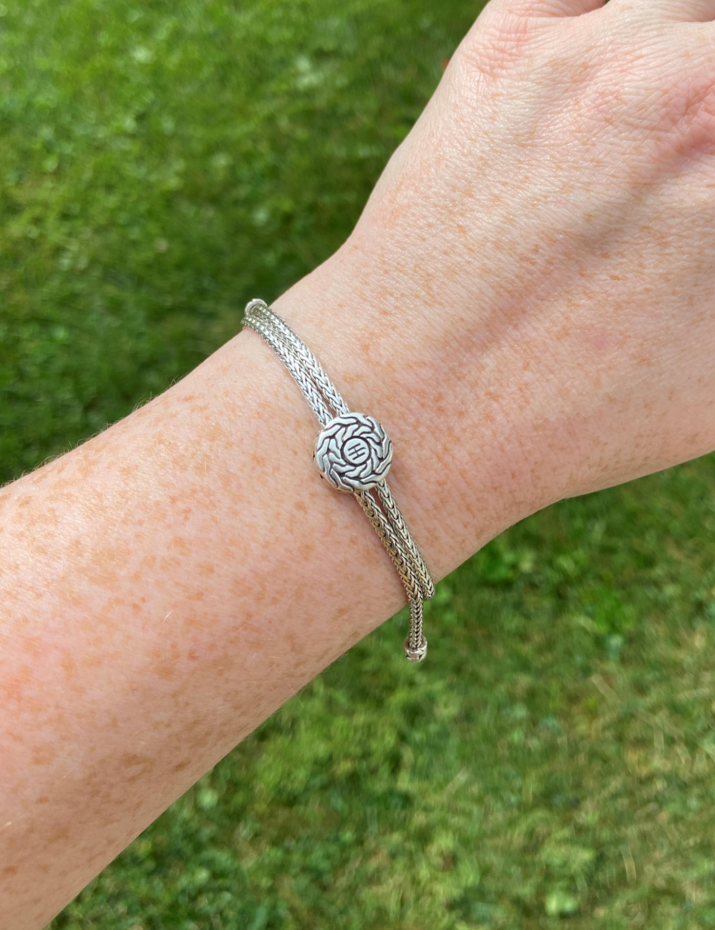 A John Hardy classic, this pull-through bracelet has such fun movement, and unlike many bracelets, it is very easy to put on and take off and is completely adjustable. The wheat chain passes through the central element that provides tension, keeping