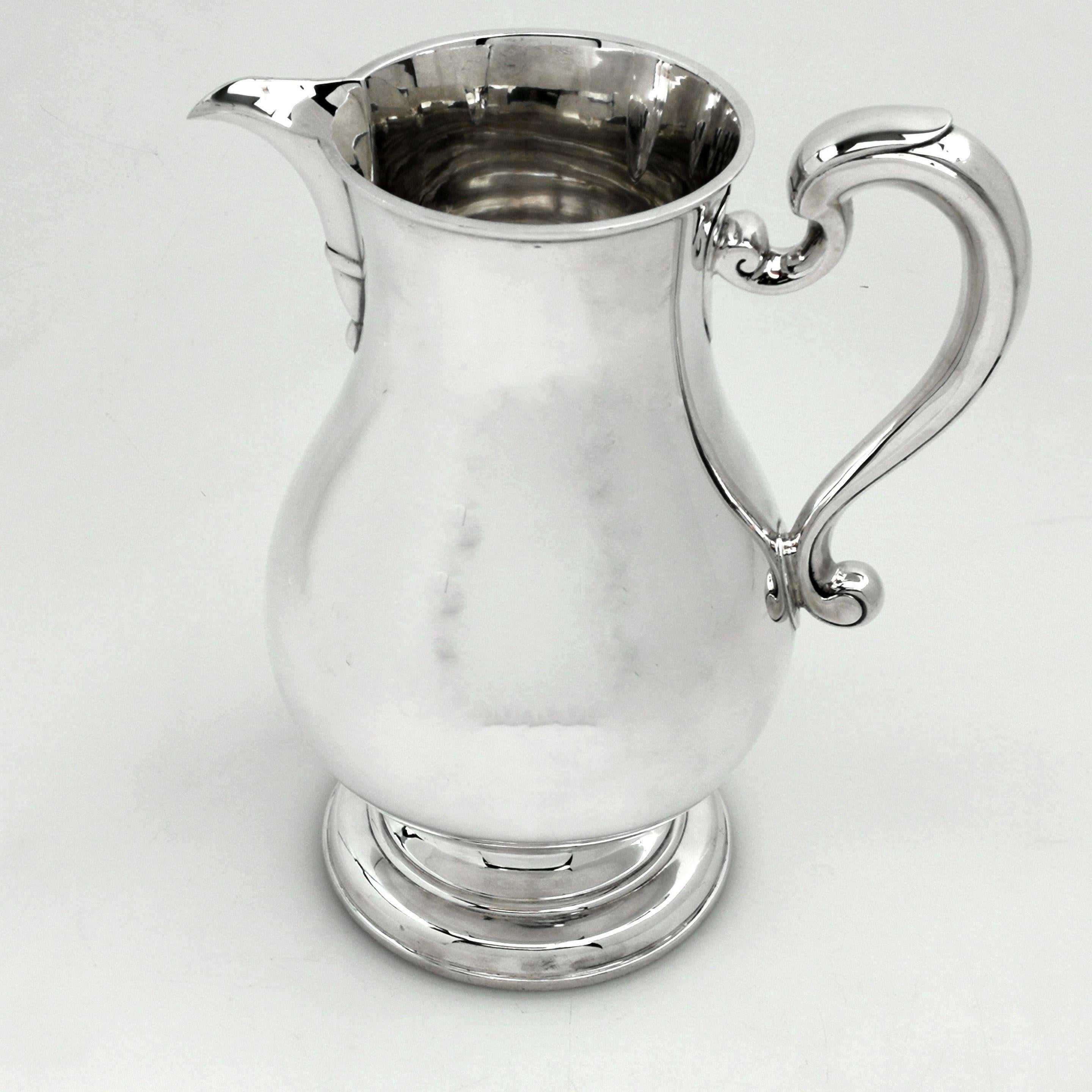 A classic solid silver jug in a plain, highly polished baluster form. This Georgian style beer jug stands on a spread pedestal foot and has a scroll handle. This Jug is of a large size, suitable for beer, water or cocktails.
 
 Made in London in