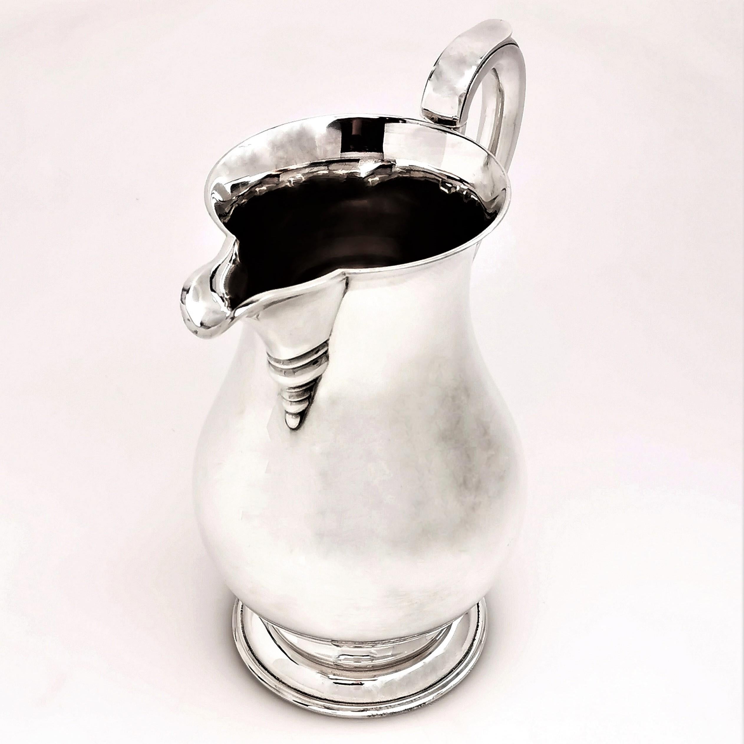 A Classic solid Silver Jug in a plain, highly polished baluster form. This Georgian style beer Jug stands on a spread pedestal foot and has a scroll handle. This Jug is of a large size, suitable for beer, water or cocktails.

Made in London in 1969