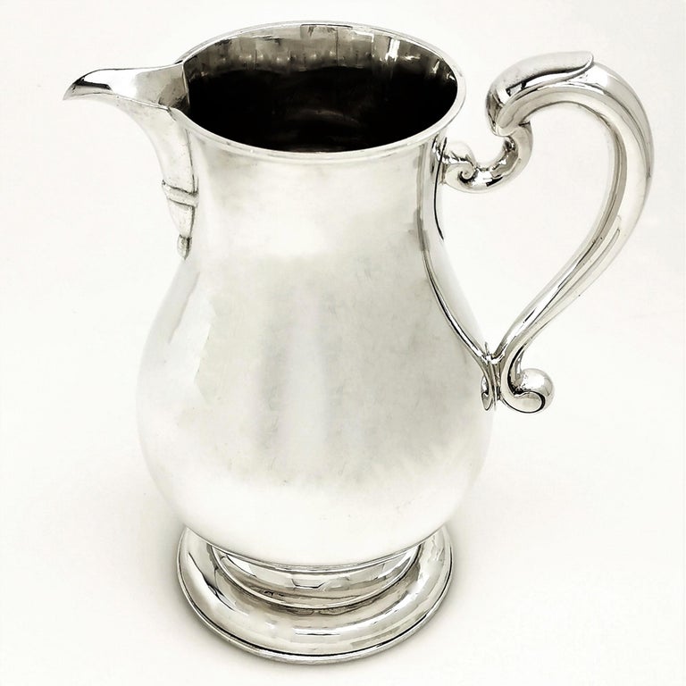 A classic solid Silver Jug in a plain, highly polished baluster form. This Georgian style Beer Jug stands on a spread pedestal foot and has a scroll handle. This Jug is of a large size, suitable for serving beer, water or cocktails.

Made in London