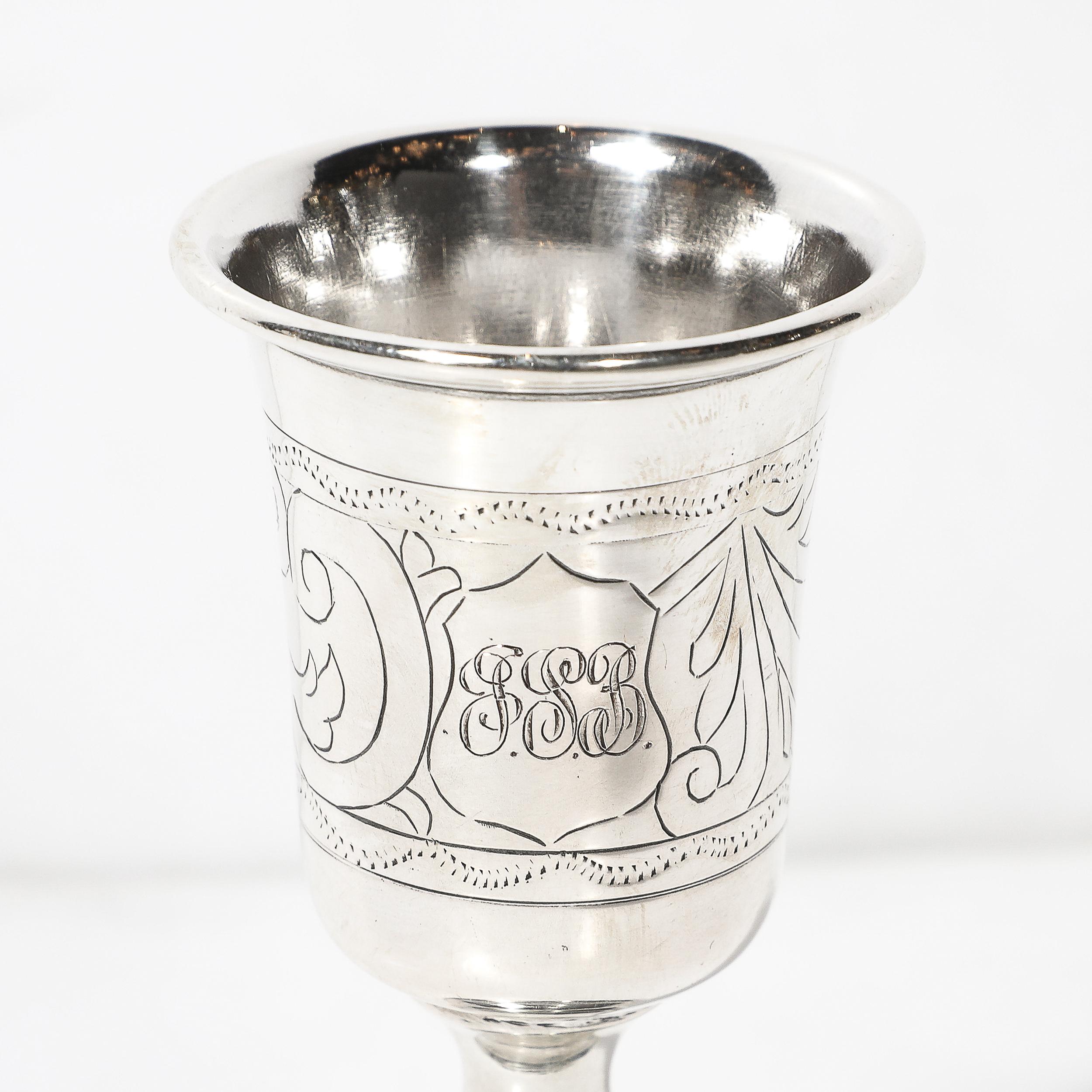Esta exquisita copa de Kiddush de plata de ley, procedente de Rusia hacia 1879, presenta intrincados detalles de acanto cincelado. Los motivos florales, magistralmente representados, ejemplifican la rica tradición de la artesanía rusa de la plata e